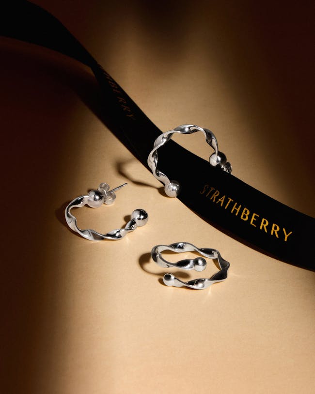 A pair of earrings and a belt on a table