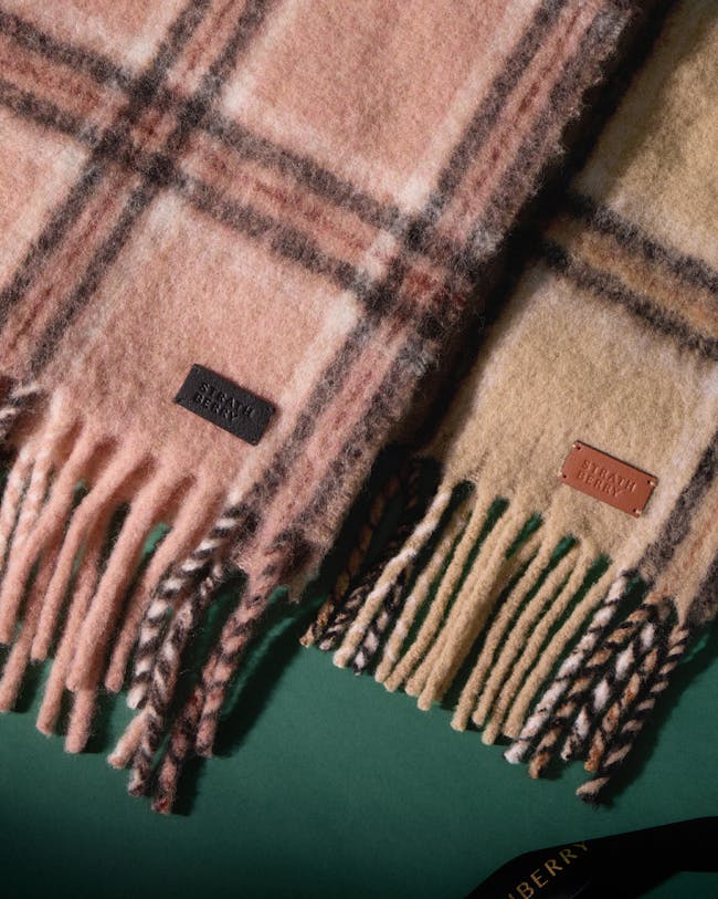 A pair of plaid scarves laying on top of a table