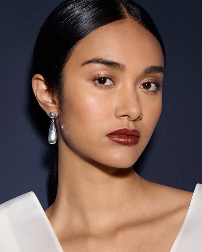 A close up of a woman wearing a white top
