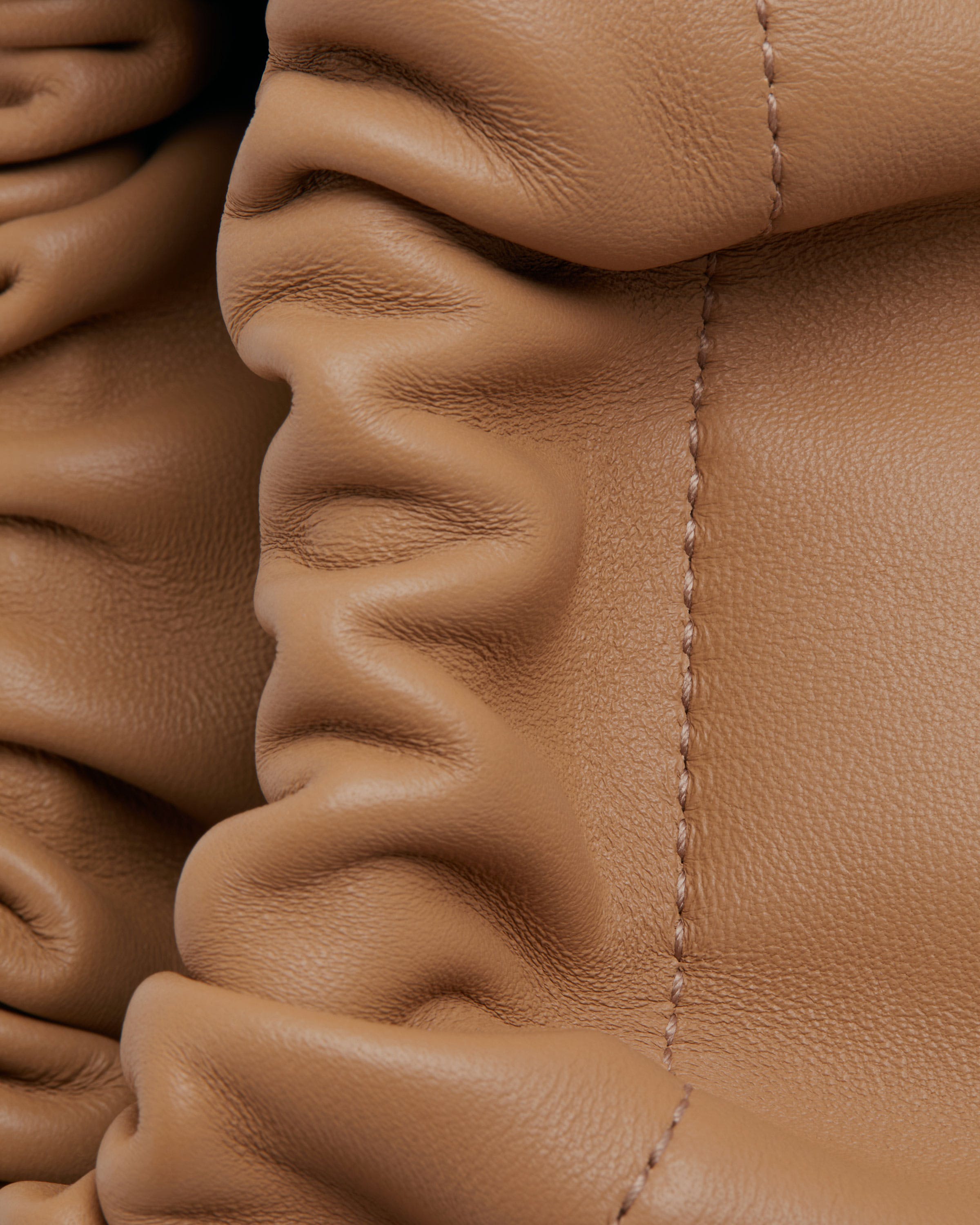 A close up of a tan leather purse