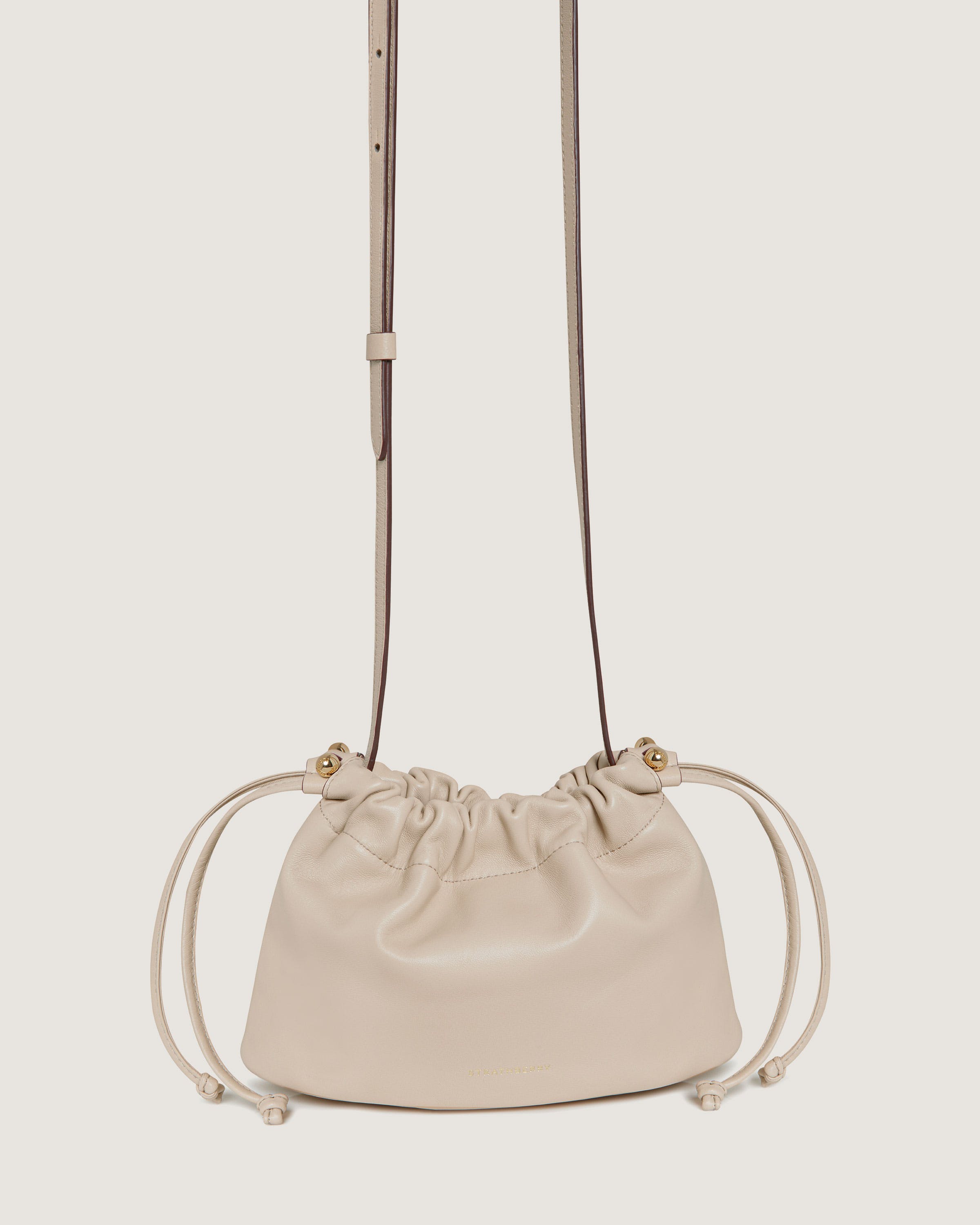 A white purse with a strap hanging from it