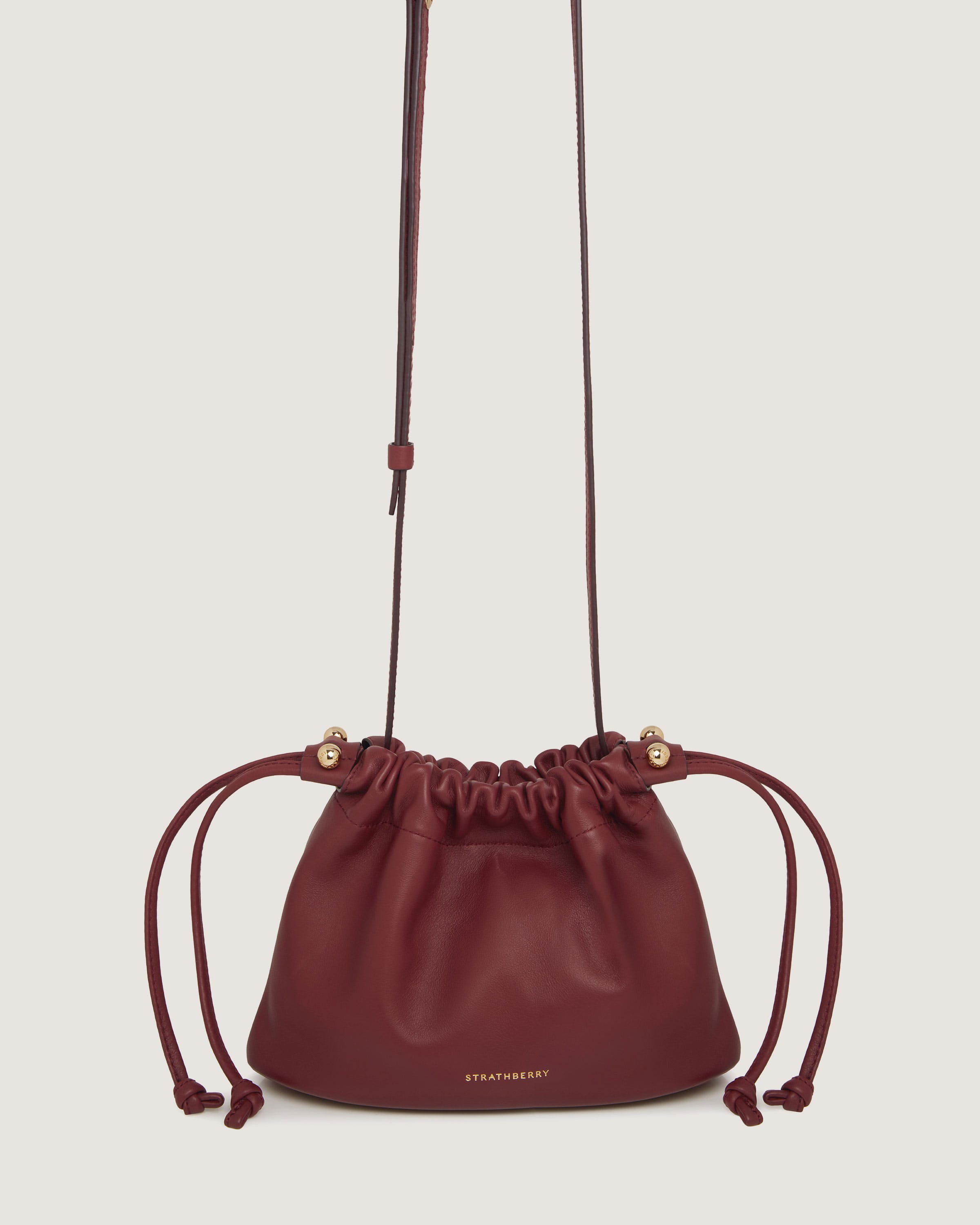 A red leather bag with a drawstring strap