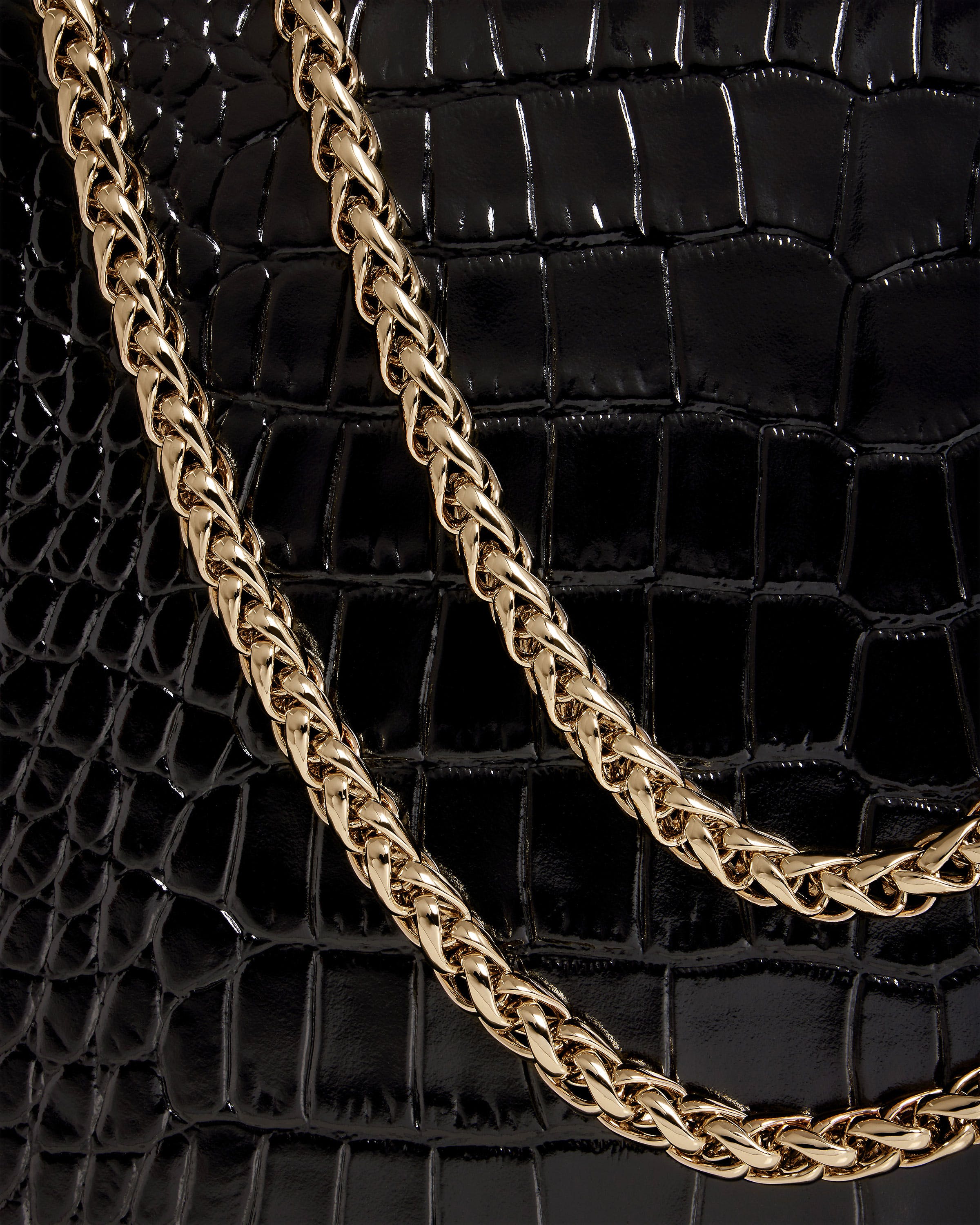 A close up of a black purse with a gold chain