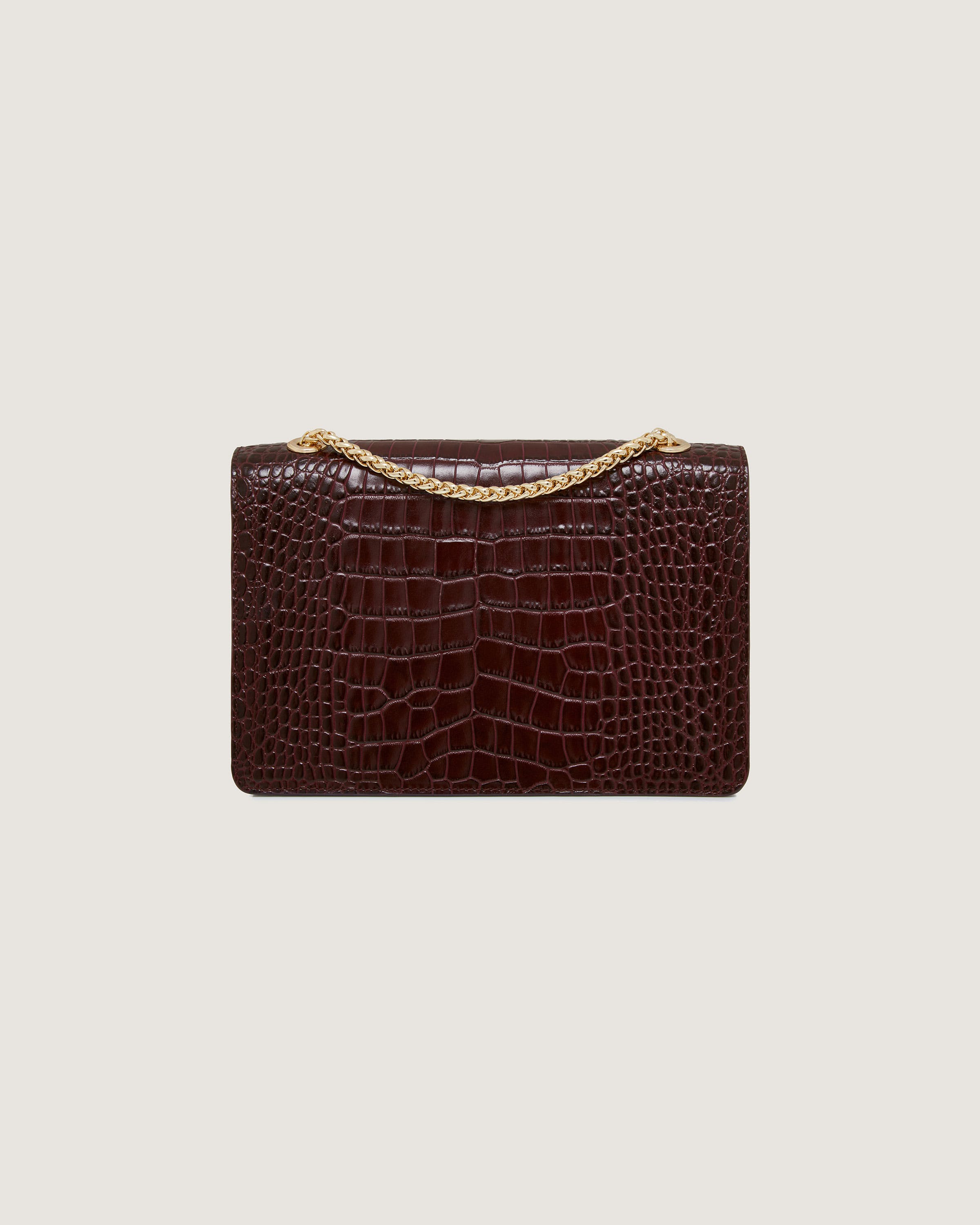 A brown crocodile skin purse with a gold chain