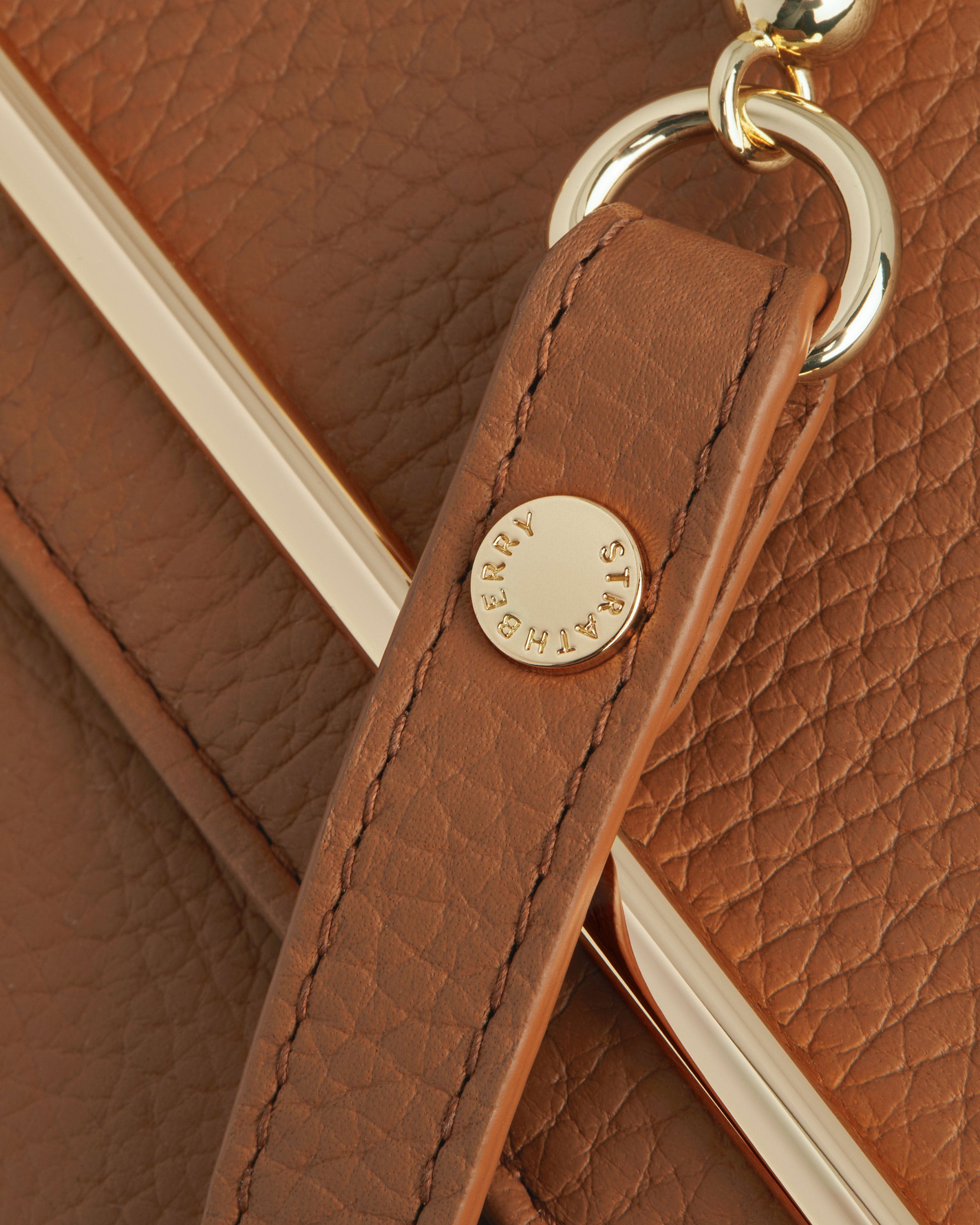 A close up of a key chain on a brown purse