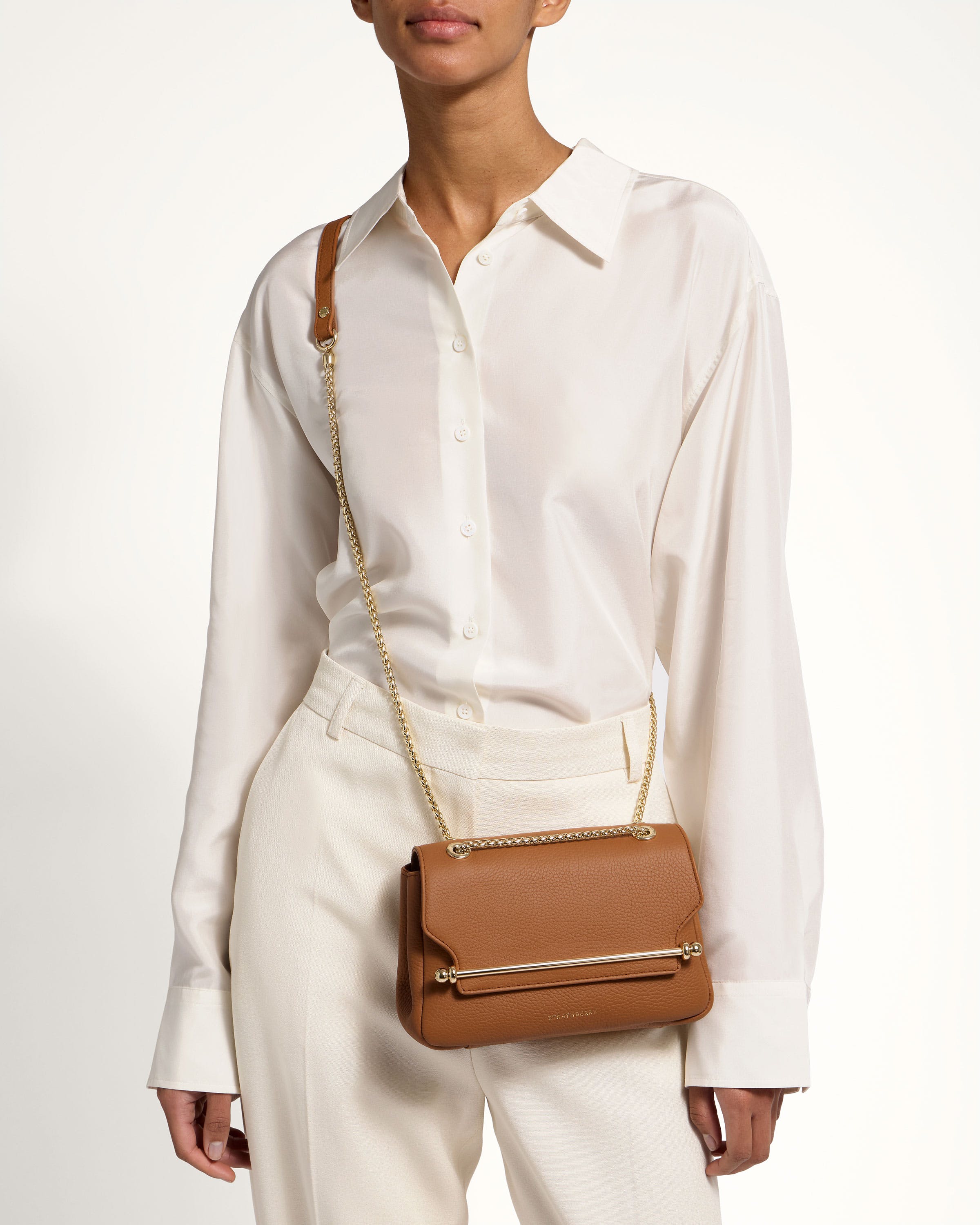 A woman in a white shirt holding a brown purse