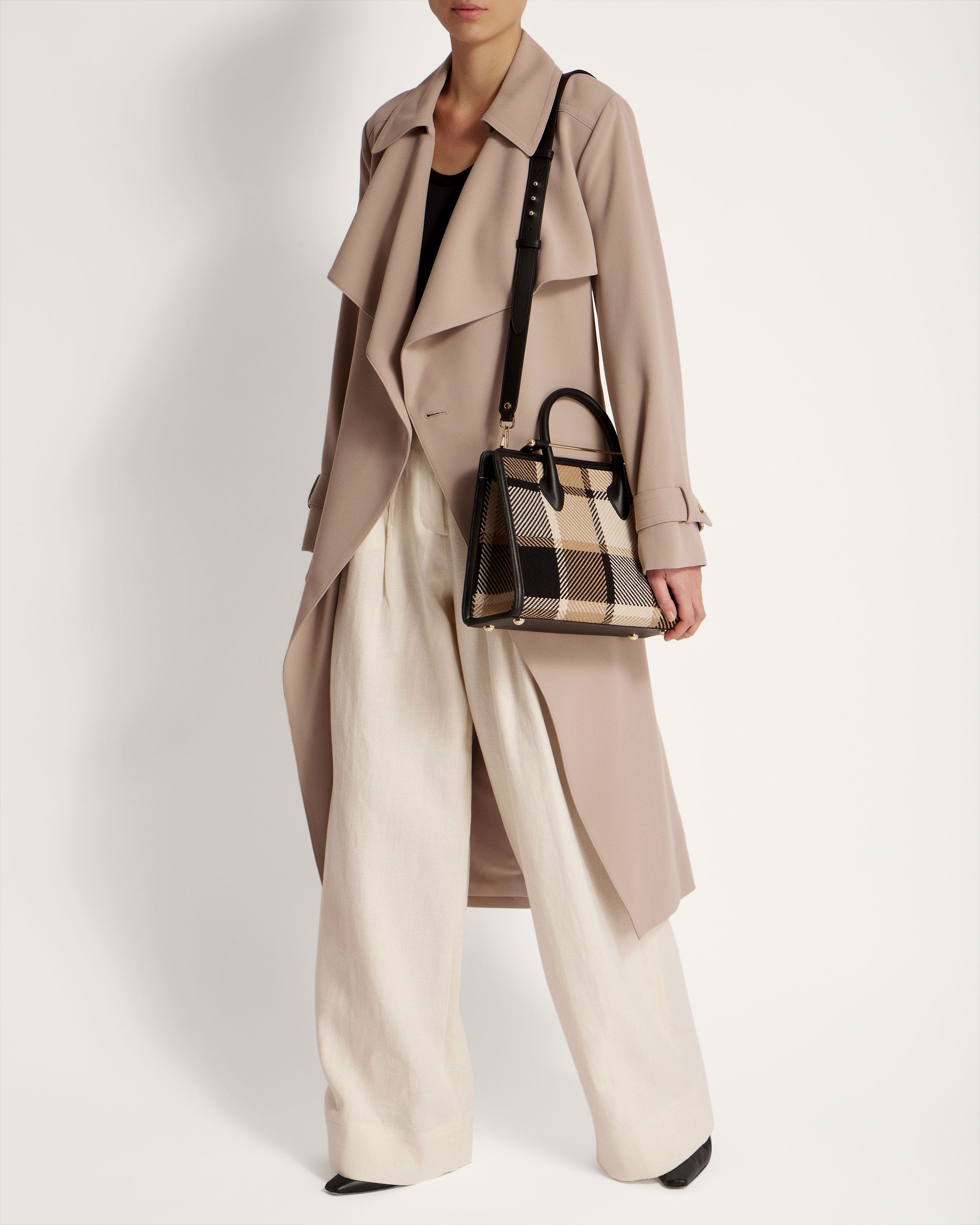 A woman in a trench coat carrying a handbag