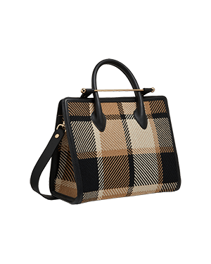 A brown and black plaid handbag on a green background