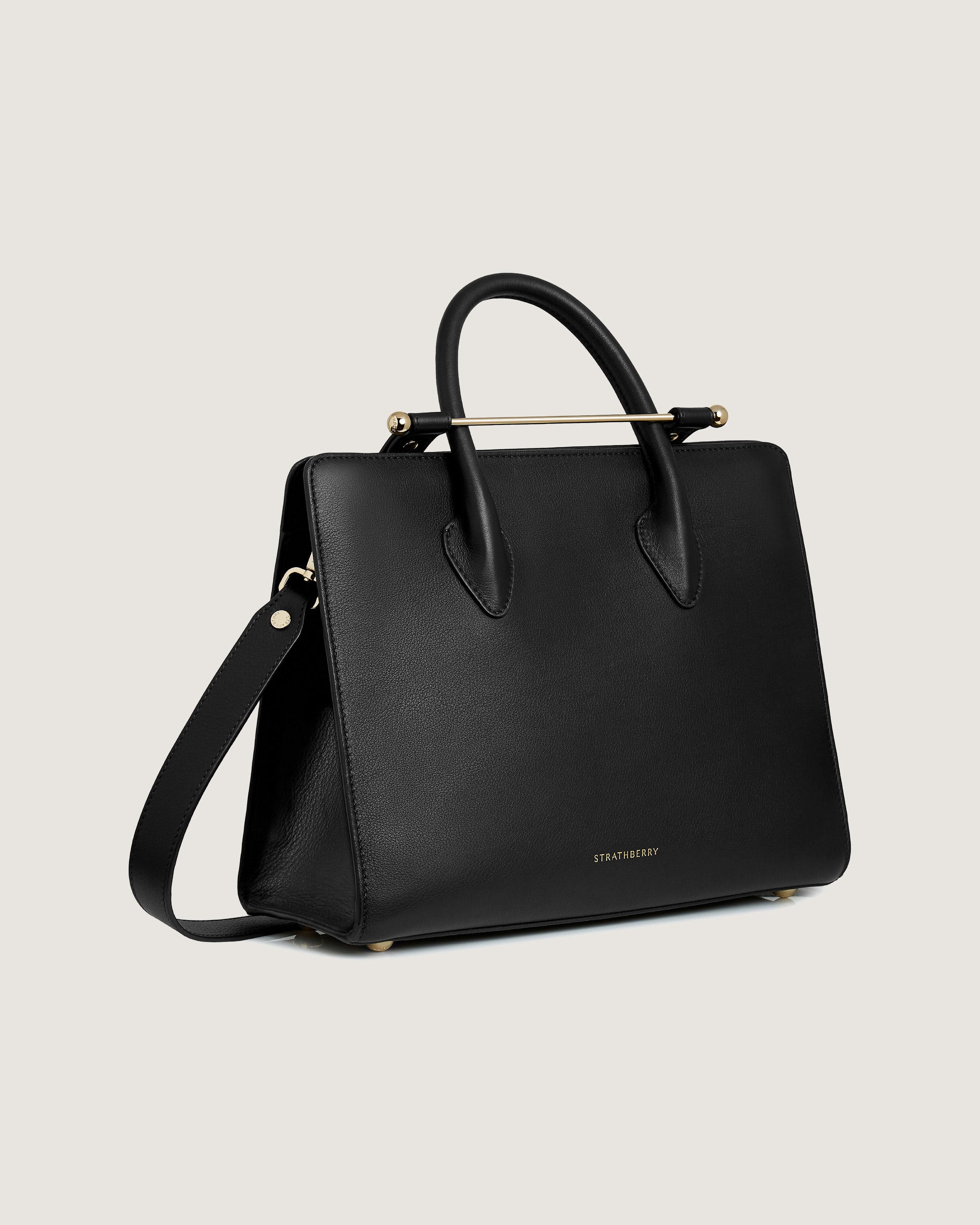 A black handbag with a gold handle