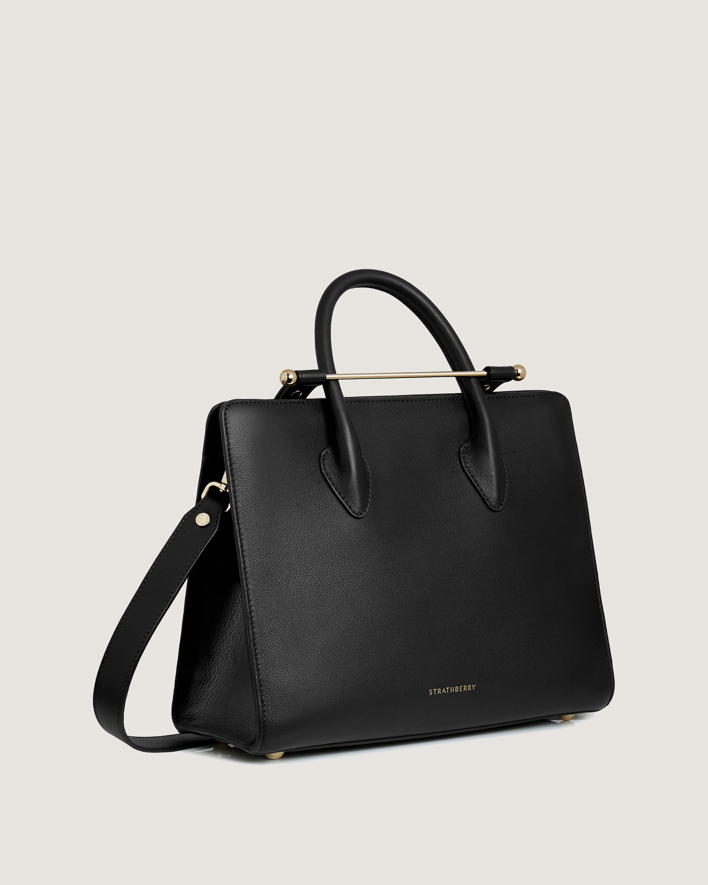 A black handbag with a gold handle