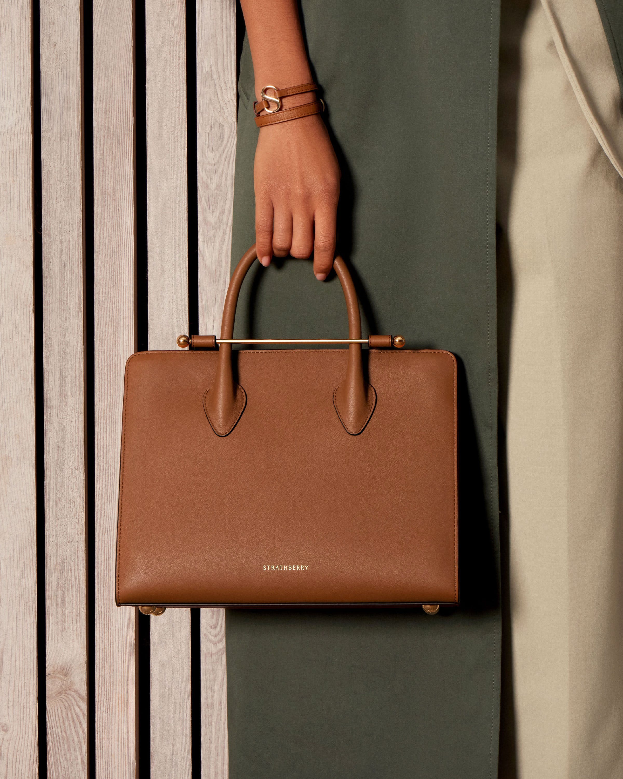 A person holding a brown bag on a wooden surface