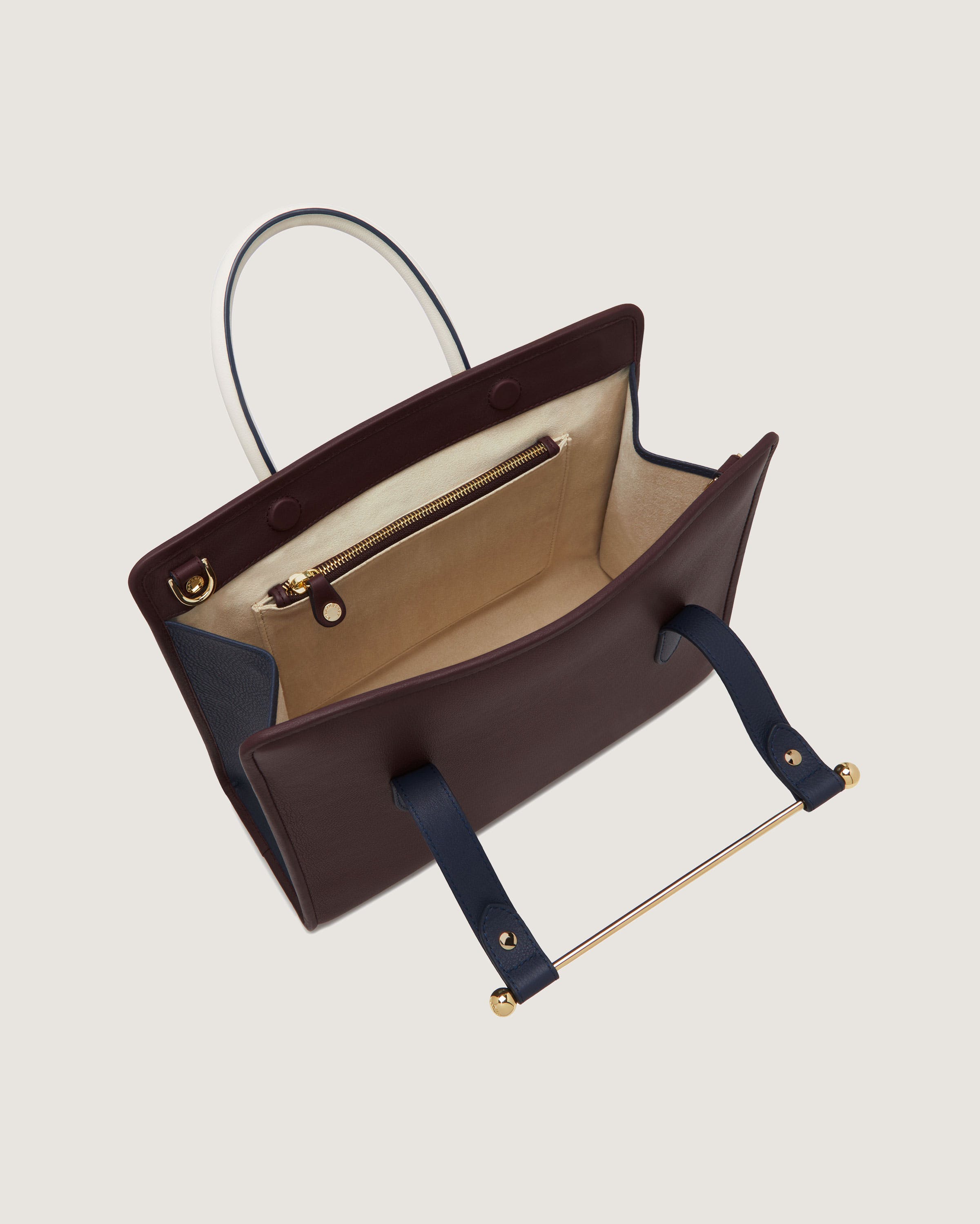 A brown and blue handbag hanging from a hook