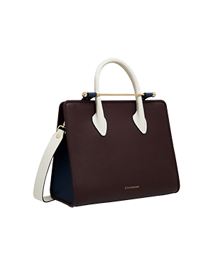 A brown and white handbag on a green background