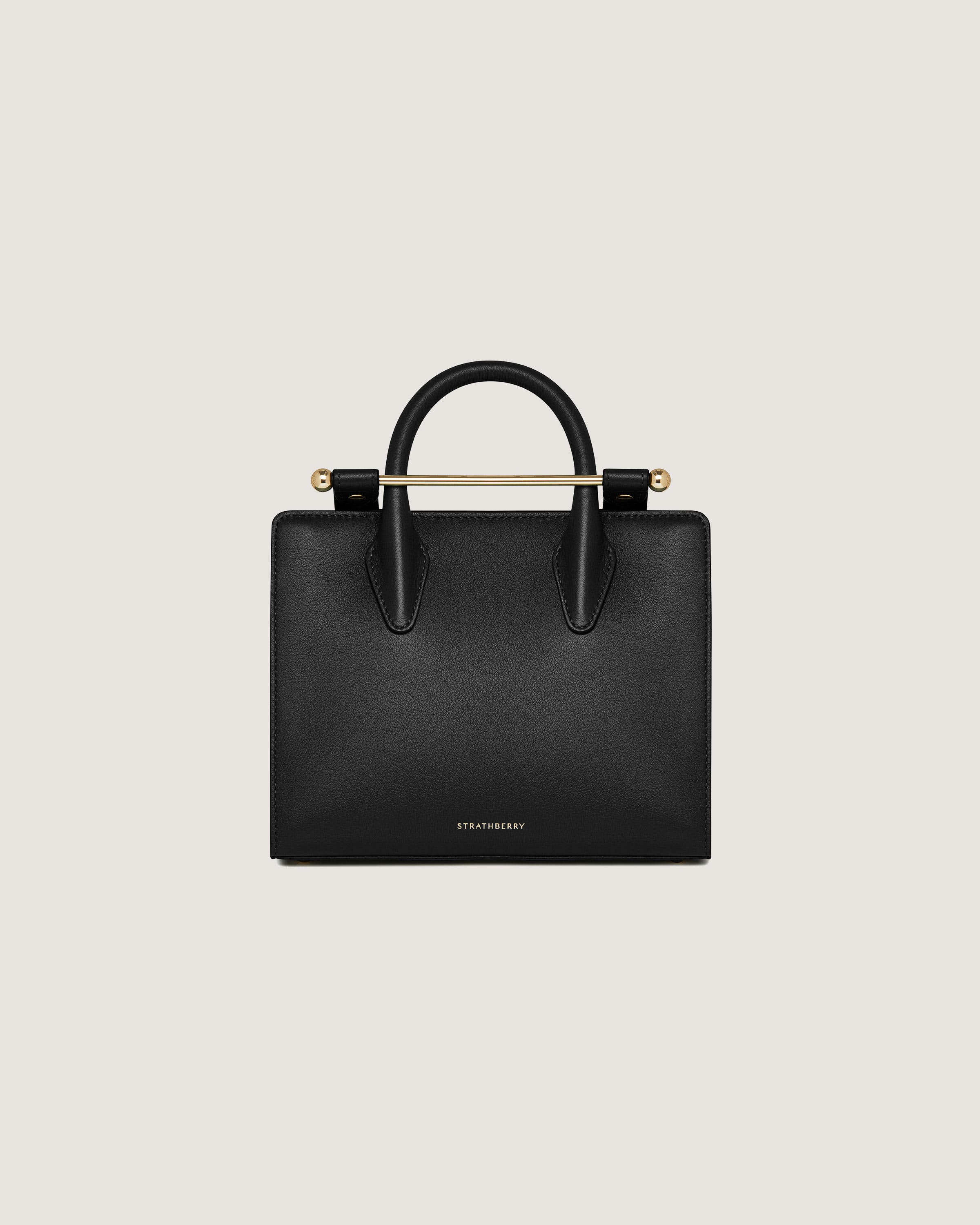 A black handbag with a gold handle