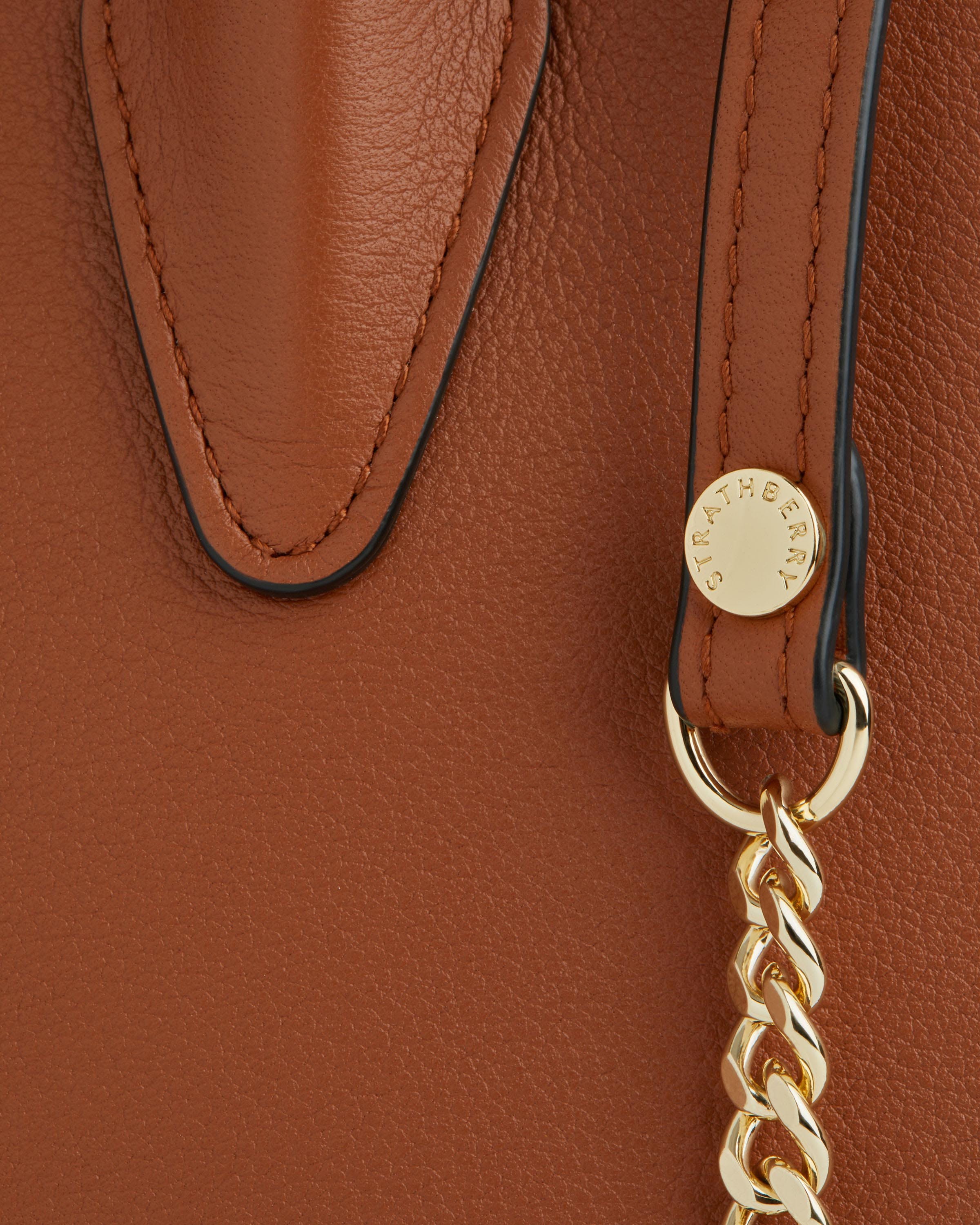 A close up of a brown purse with a gold chain