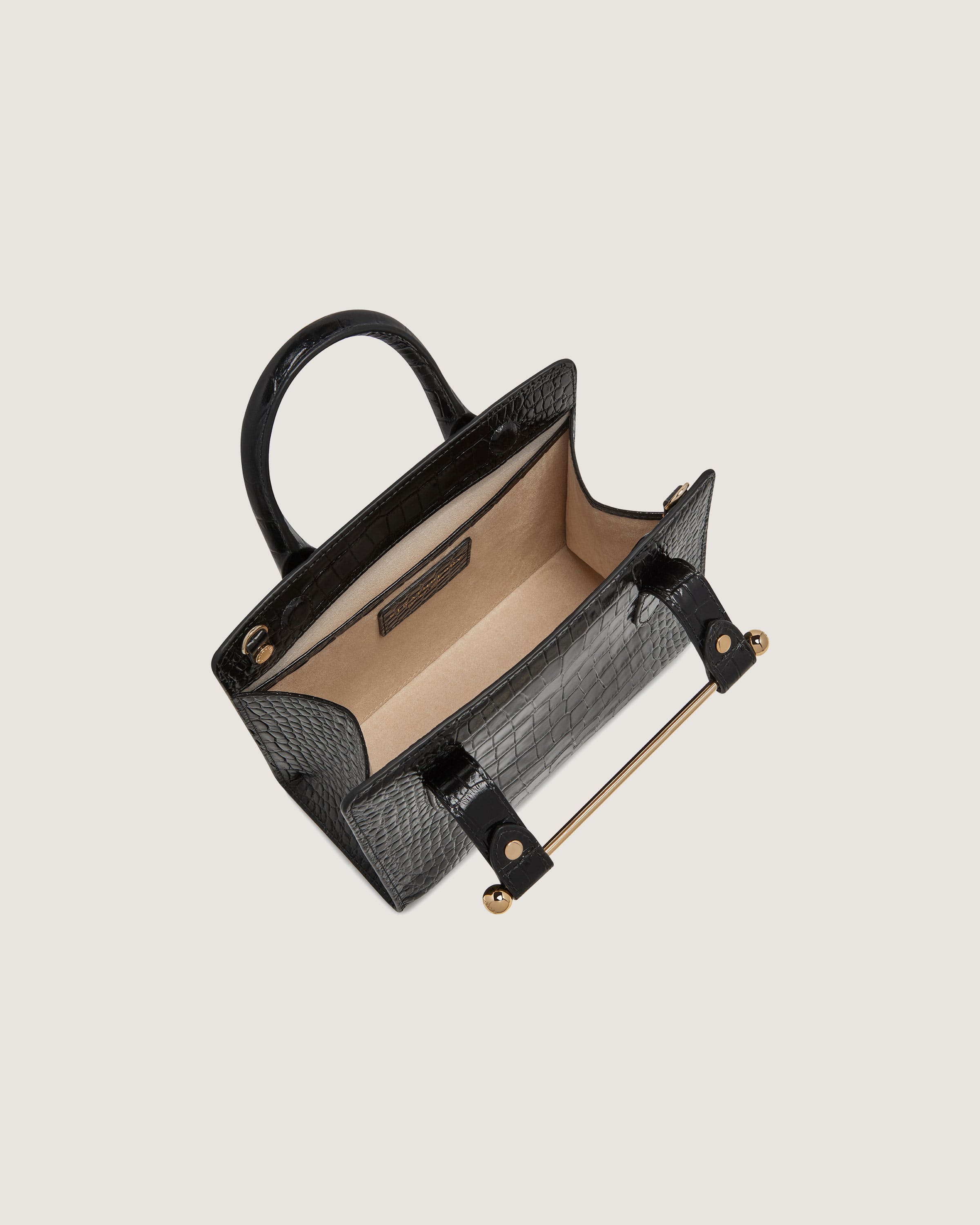 A black handbag with a gold handle