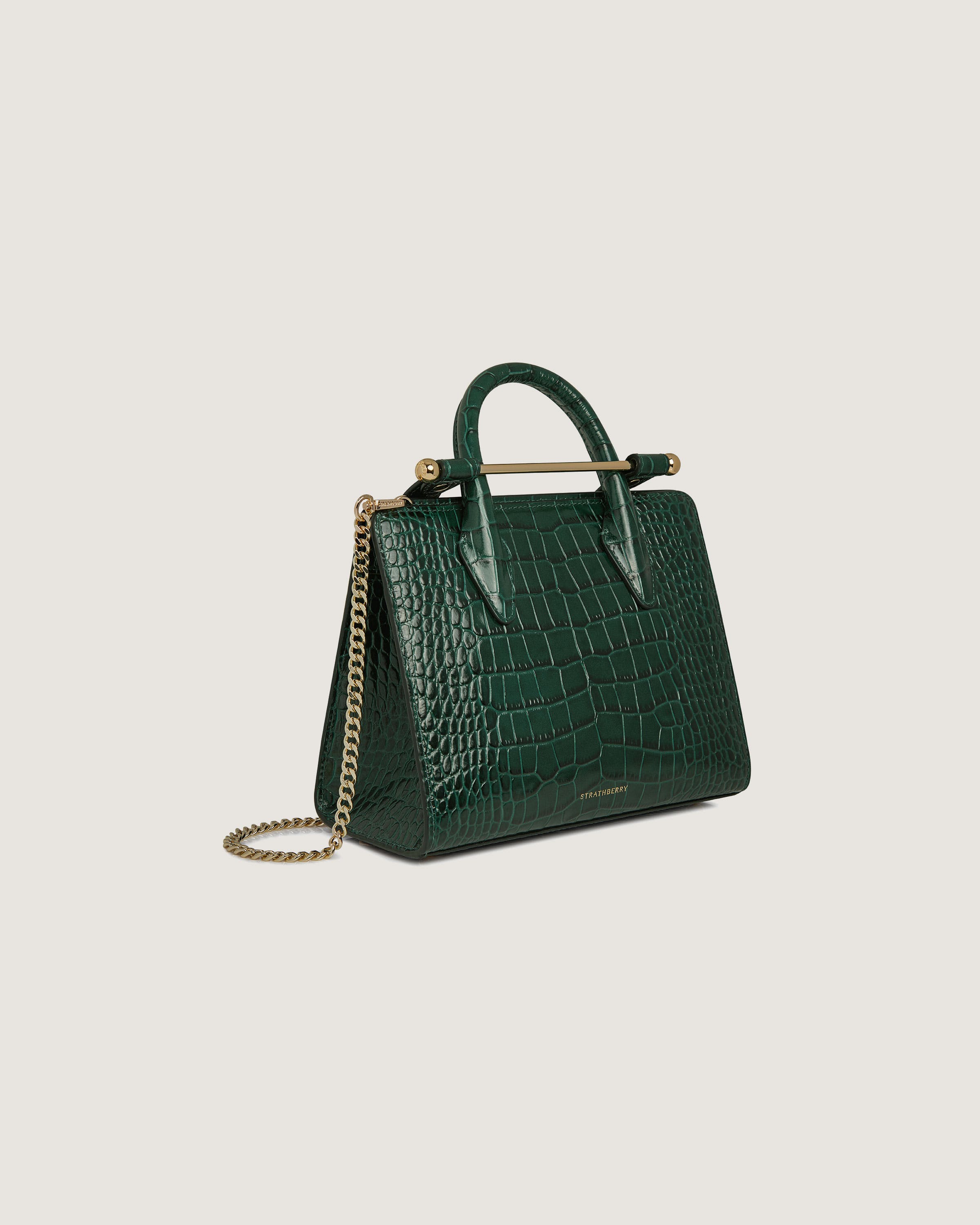 A green handbag with a gold handle