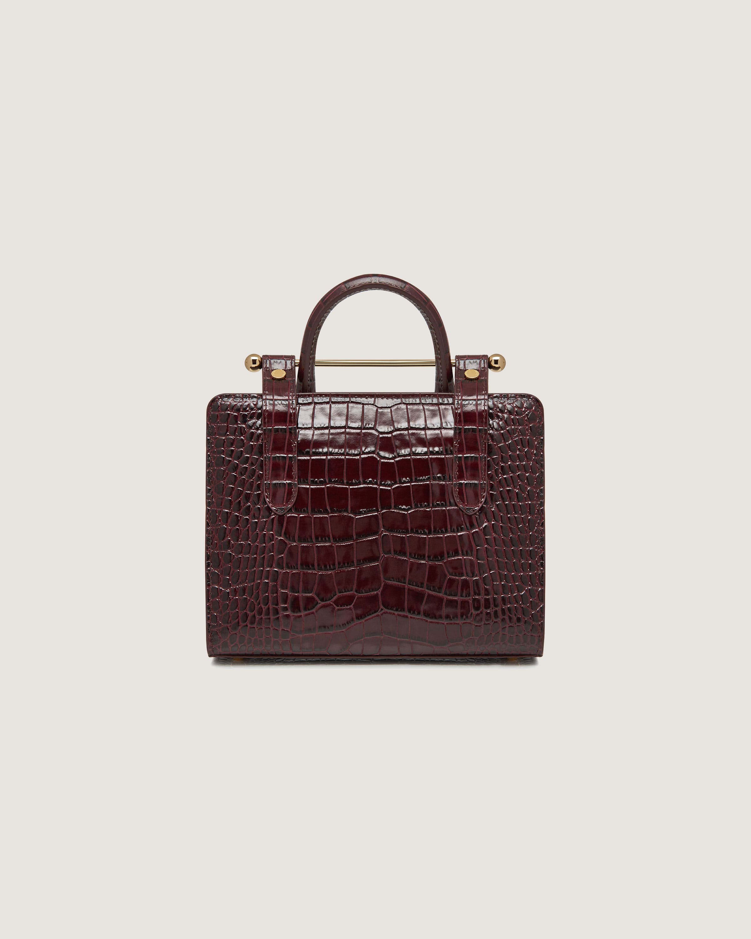 A brown crocodile skin bag with a handle