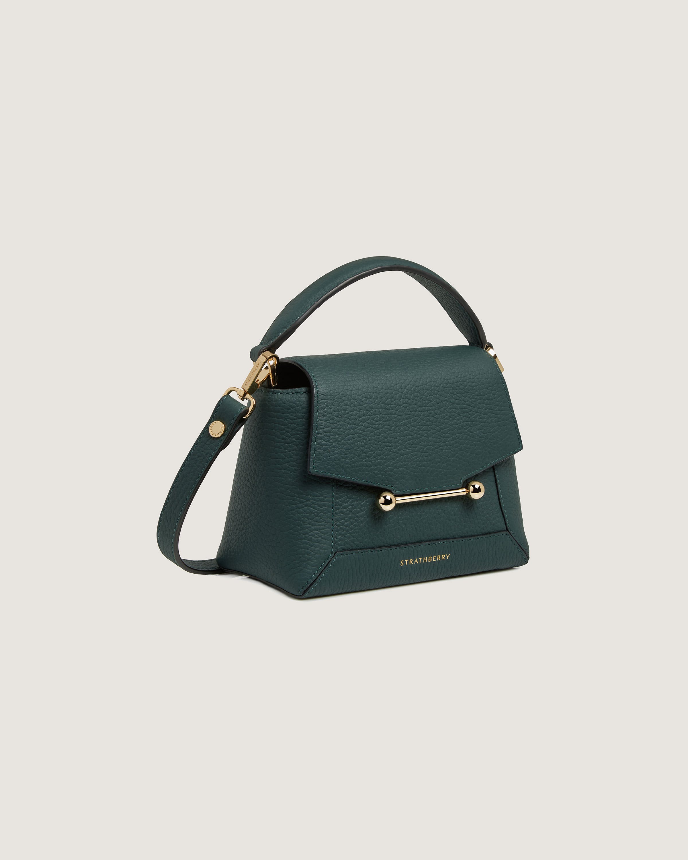 A green handbag with a gold handle