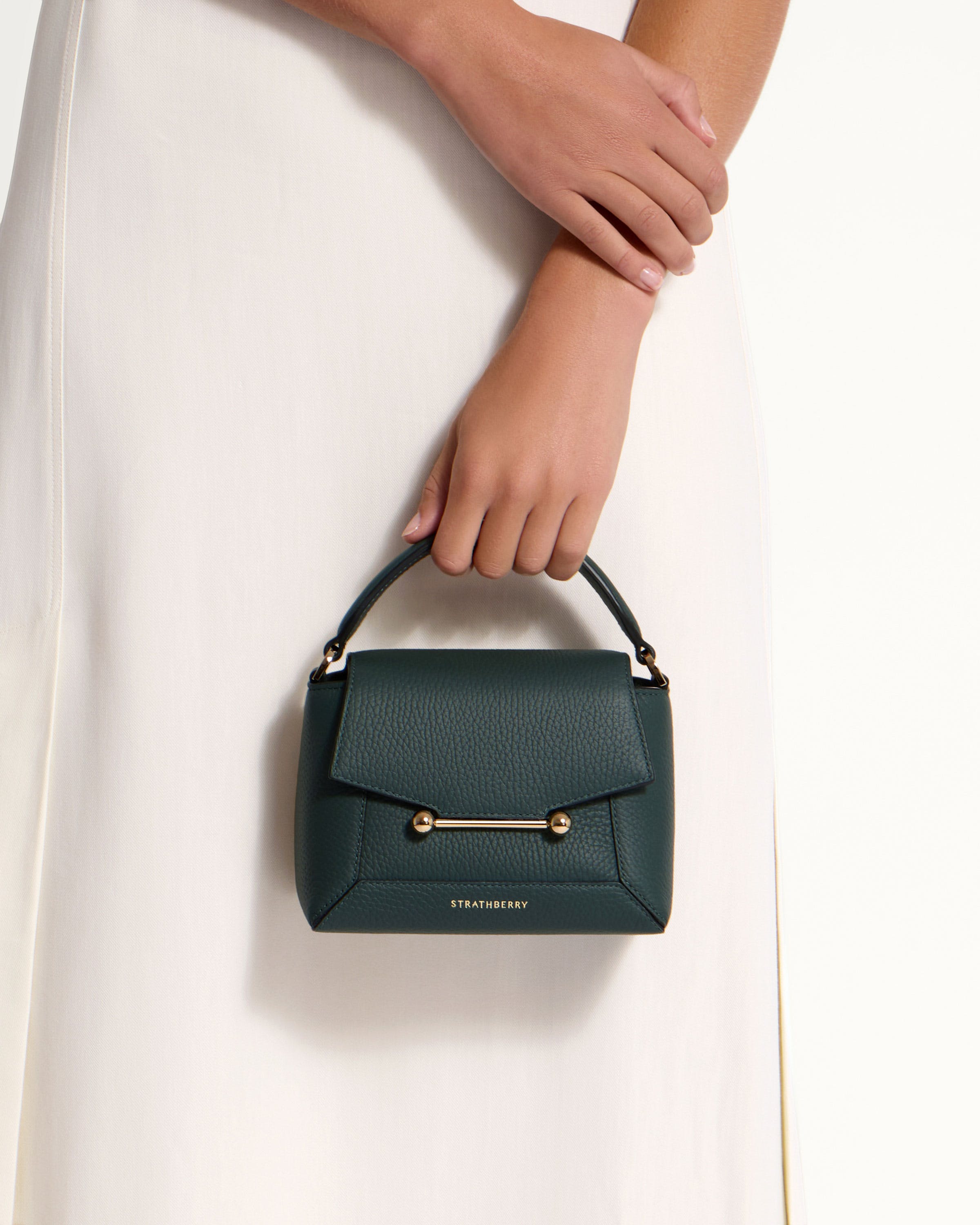 A woman's hand holding a green purse