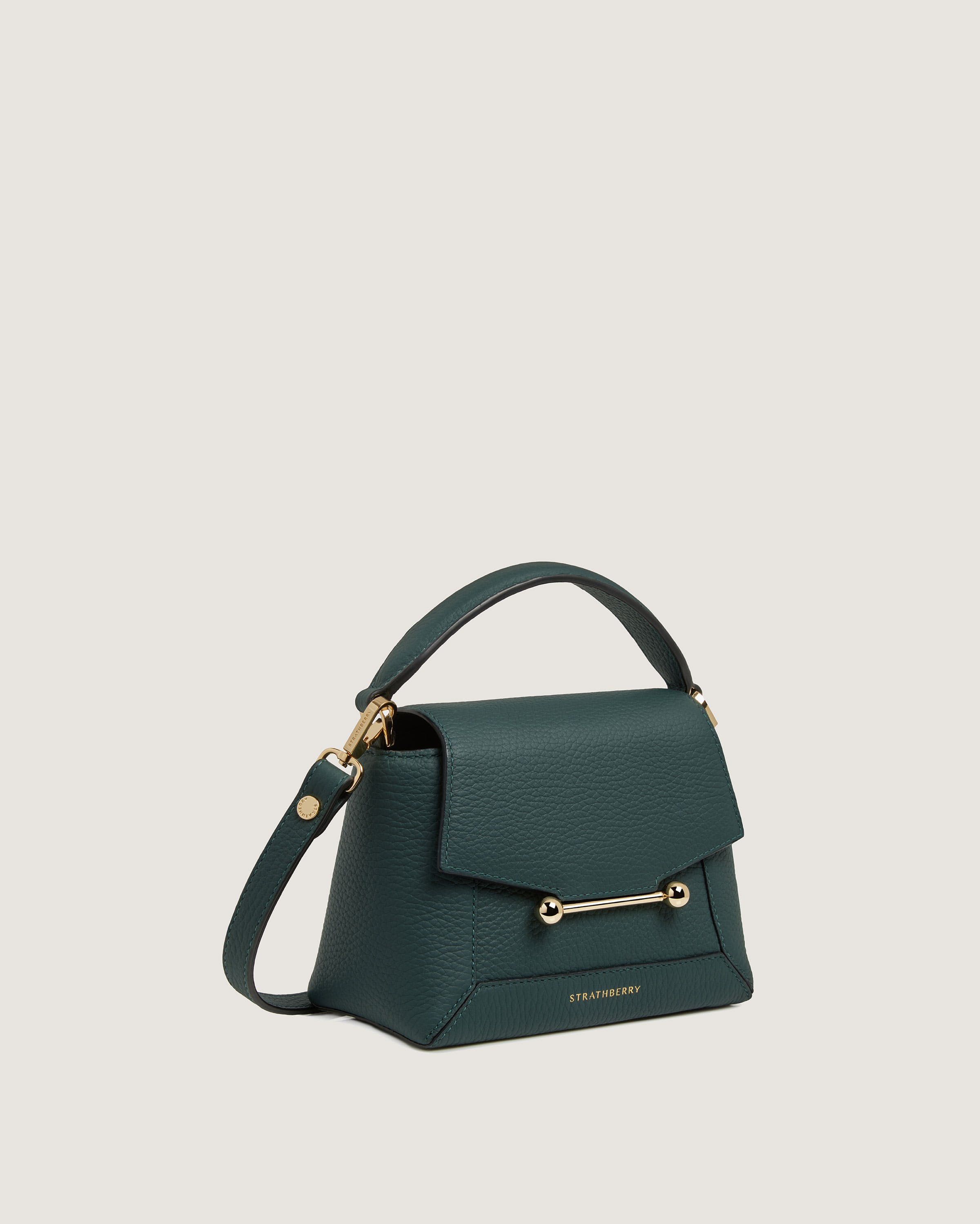 A green handbag with a gold handle