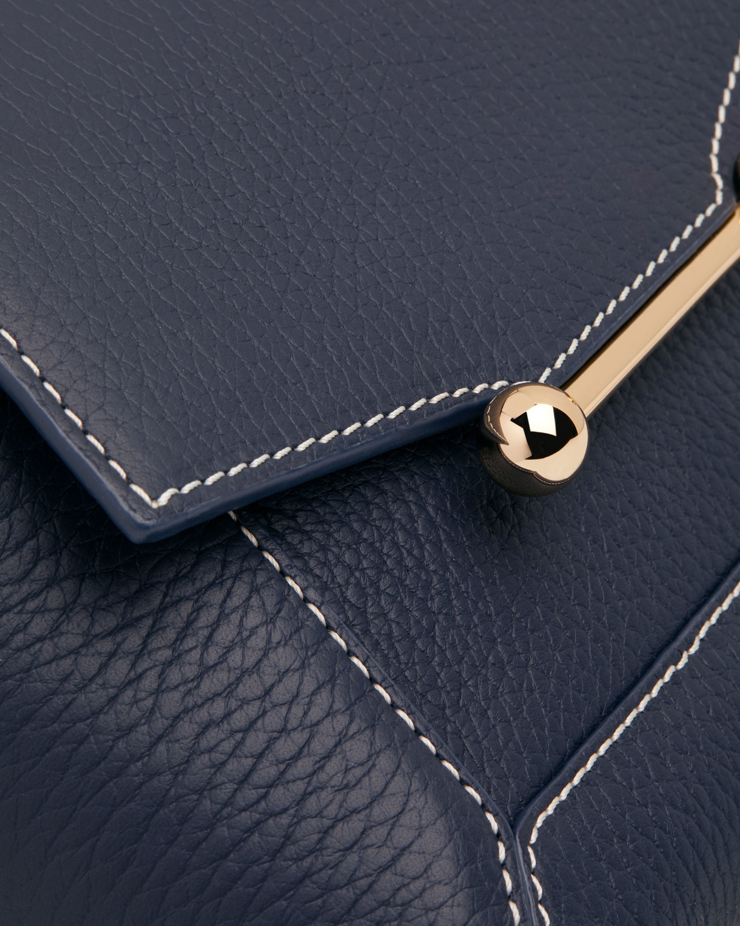 A close up of a blue purse with a gold handle