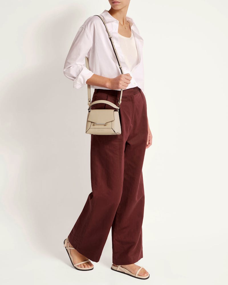 A woman wearing a white shirt and brown pants