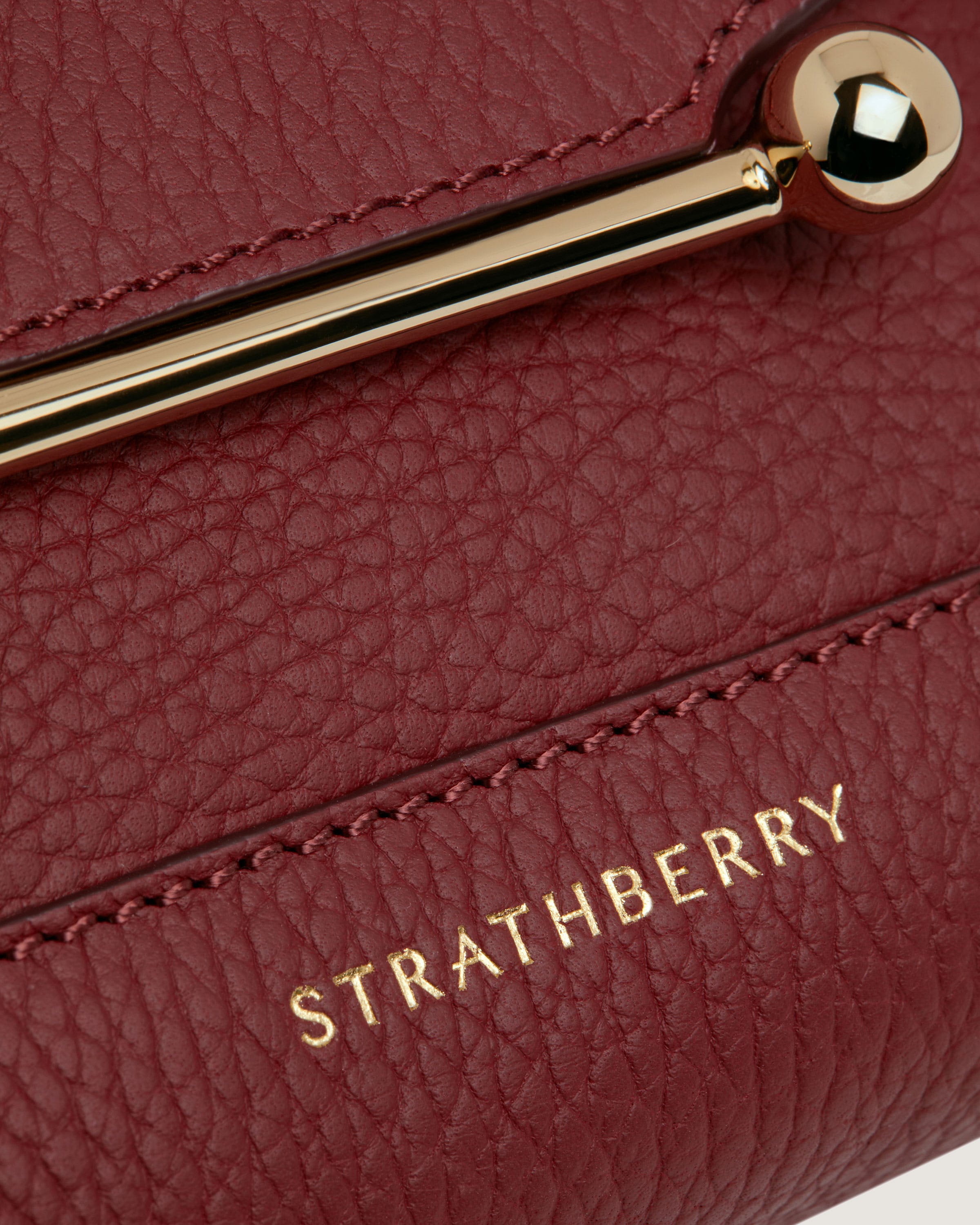 A close up of a red purse with a gold handle