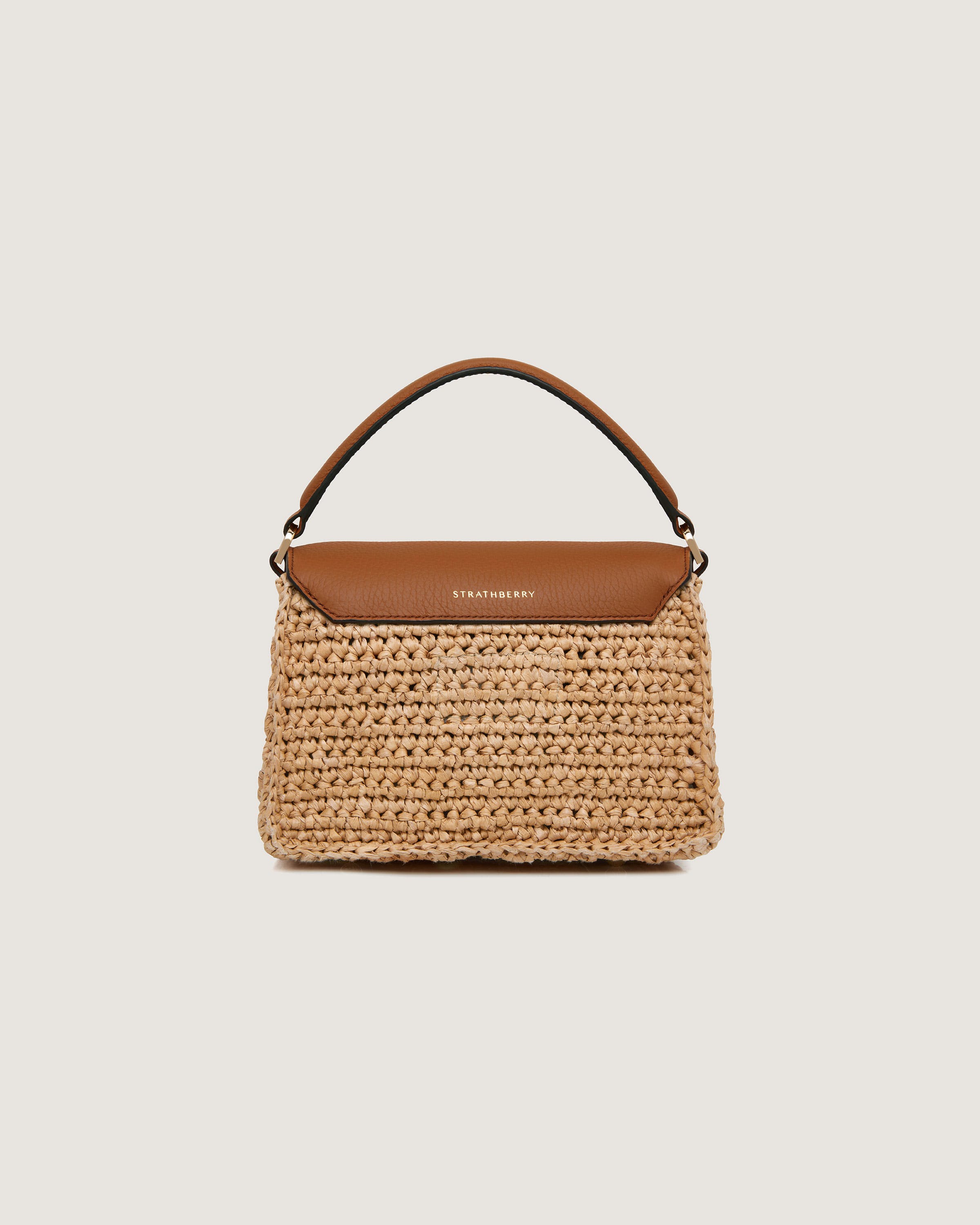 A straw bag with a brown leather handle