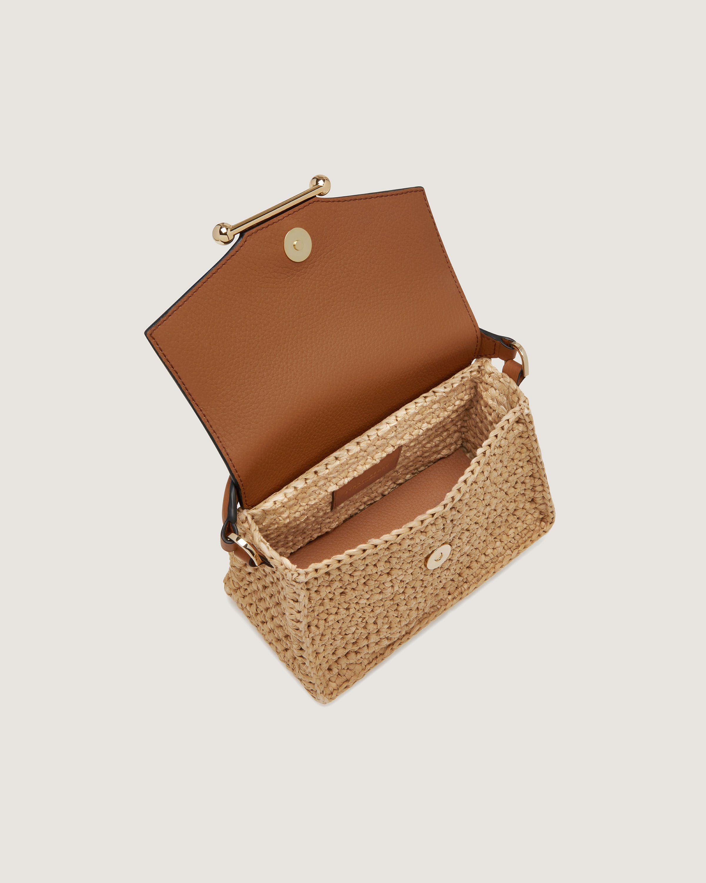 A straw bag with a brown handle on a white background