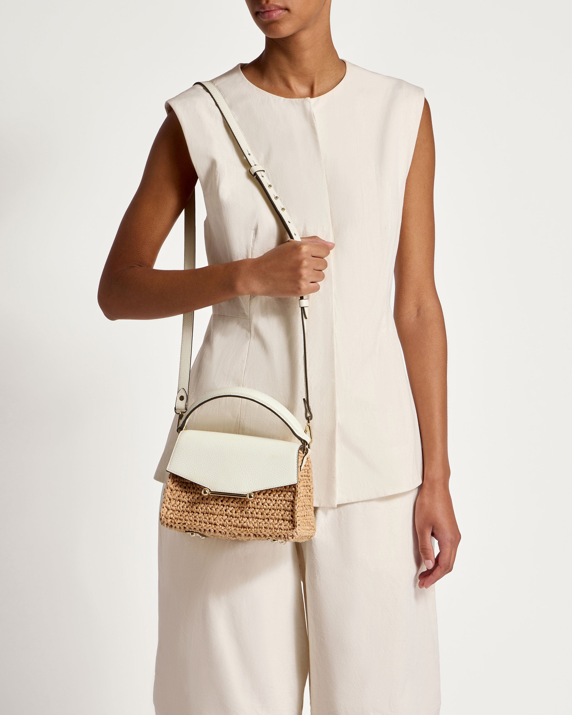 A woman is holding a white purse