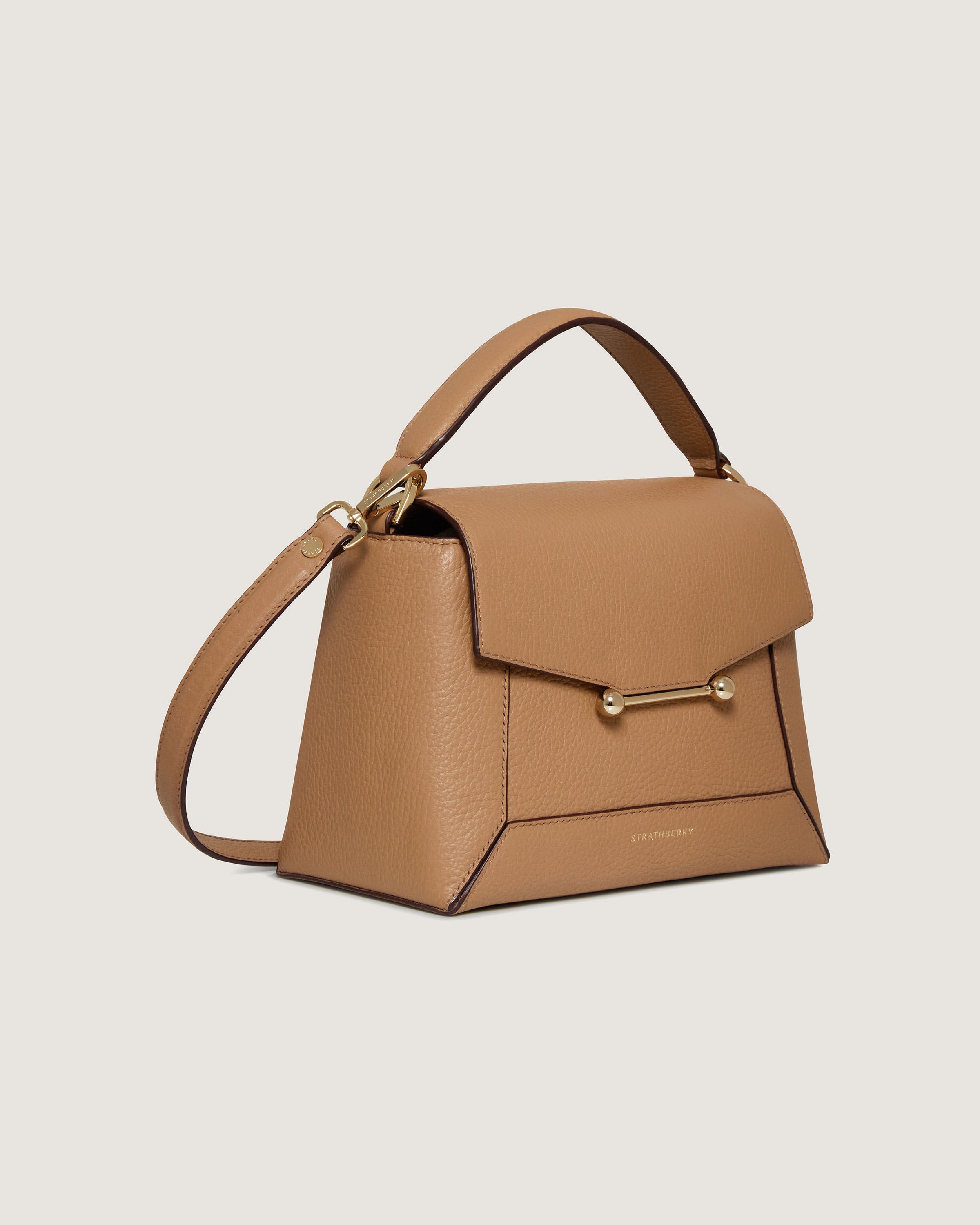 A tan leather handbag on a white background