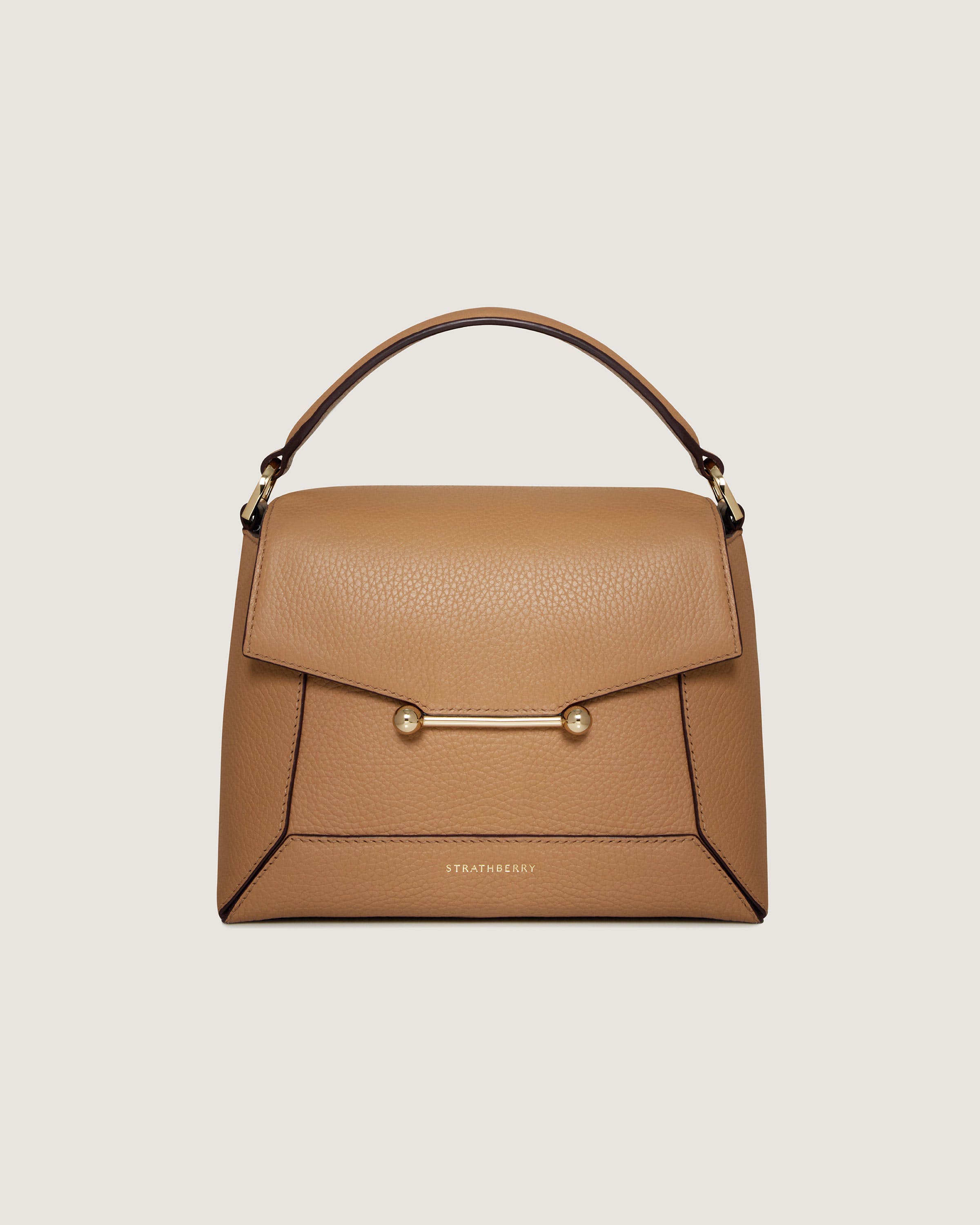 A tan handbag with a gold handle