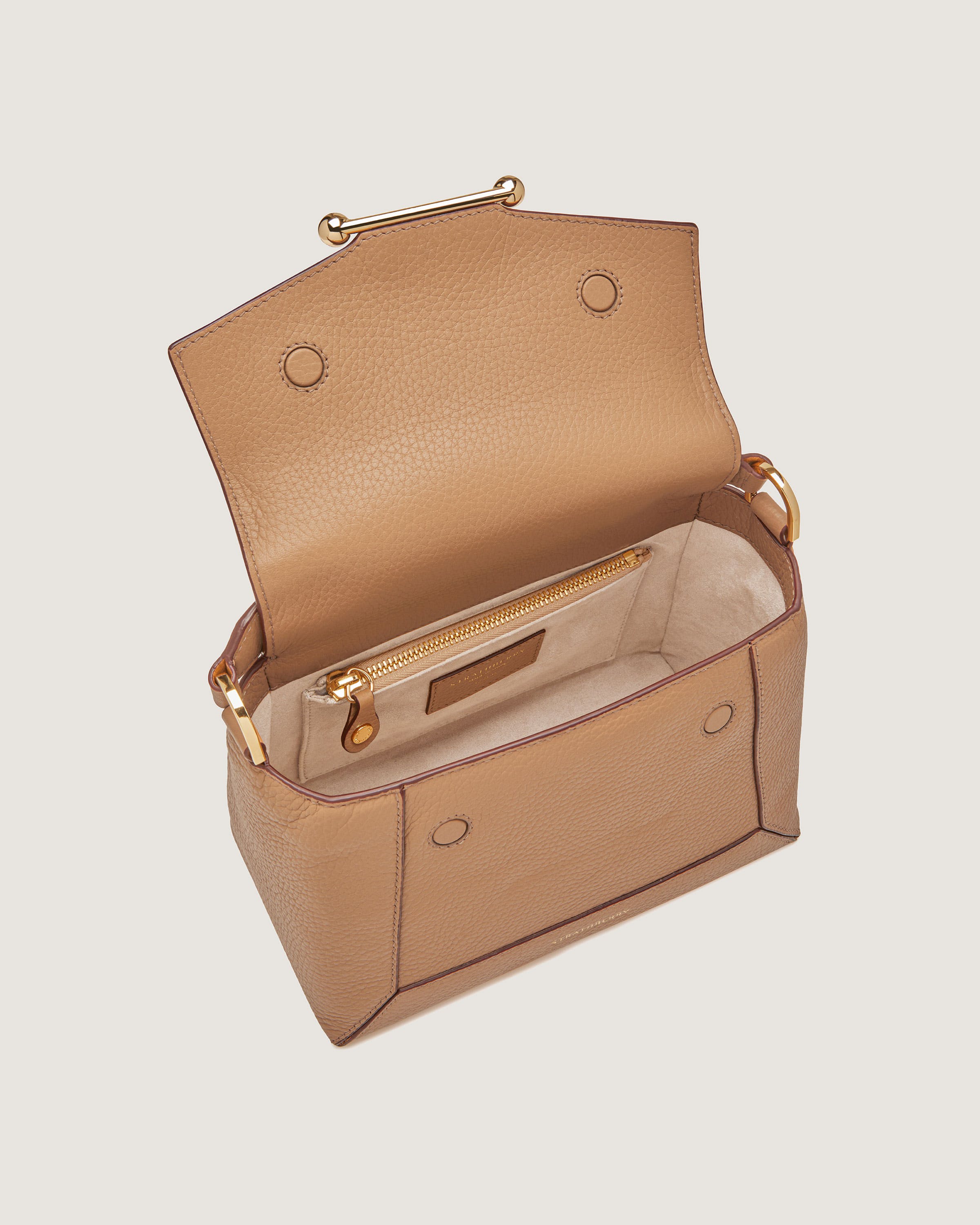 A tan handbag with a zippered compartment