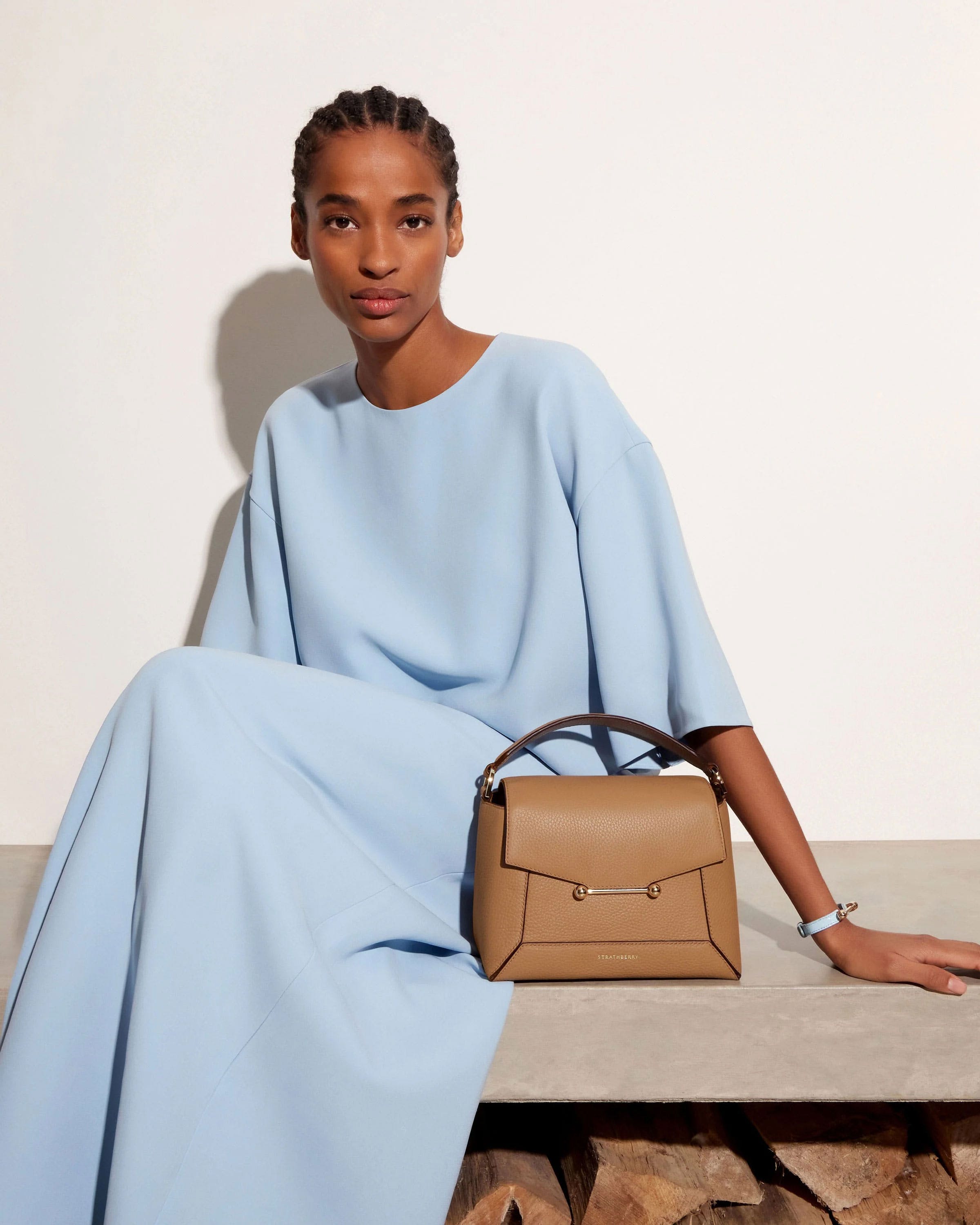 A woman sitting on a bench with a handbag