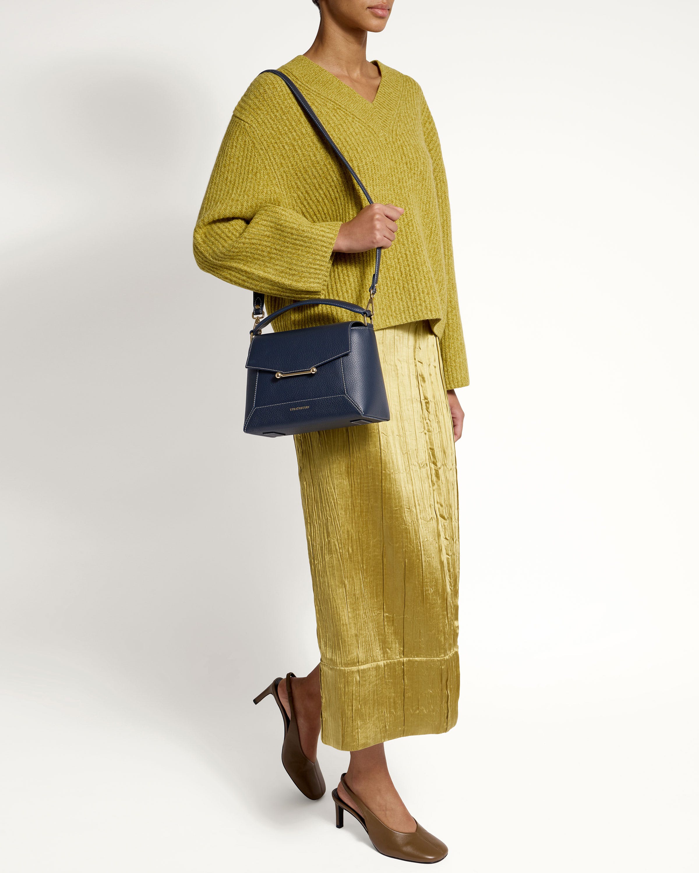 A woman in a yellow dress holding a blue purse