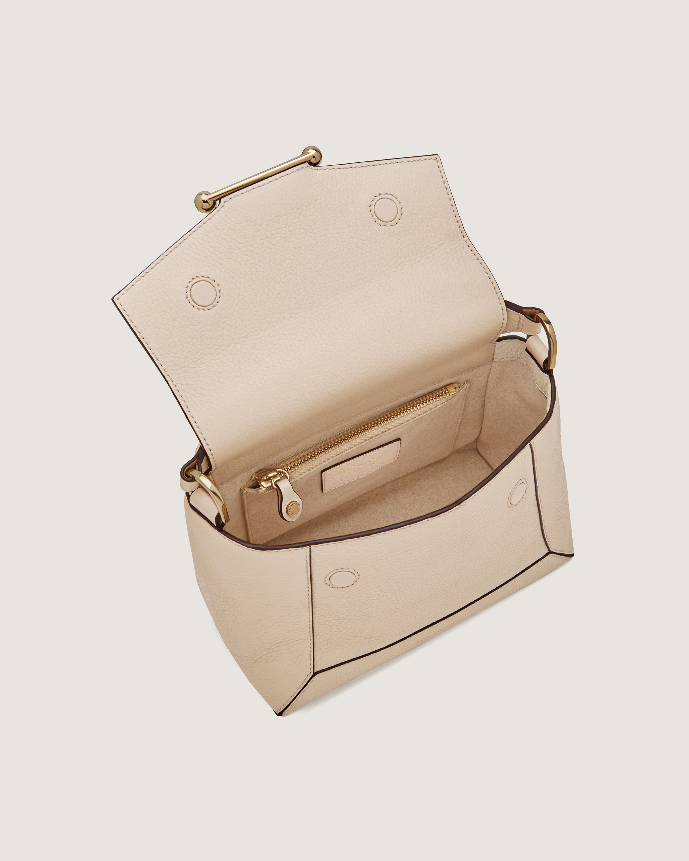 A white handbag with a gold handle on a white background