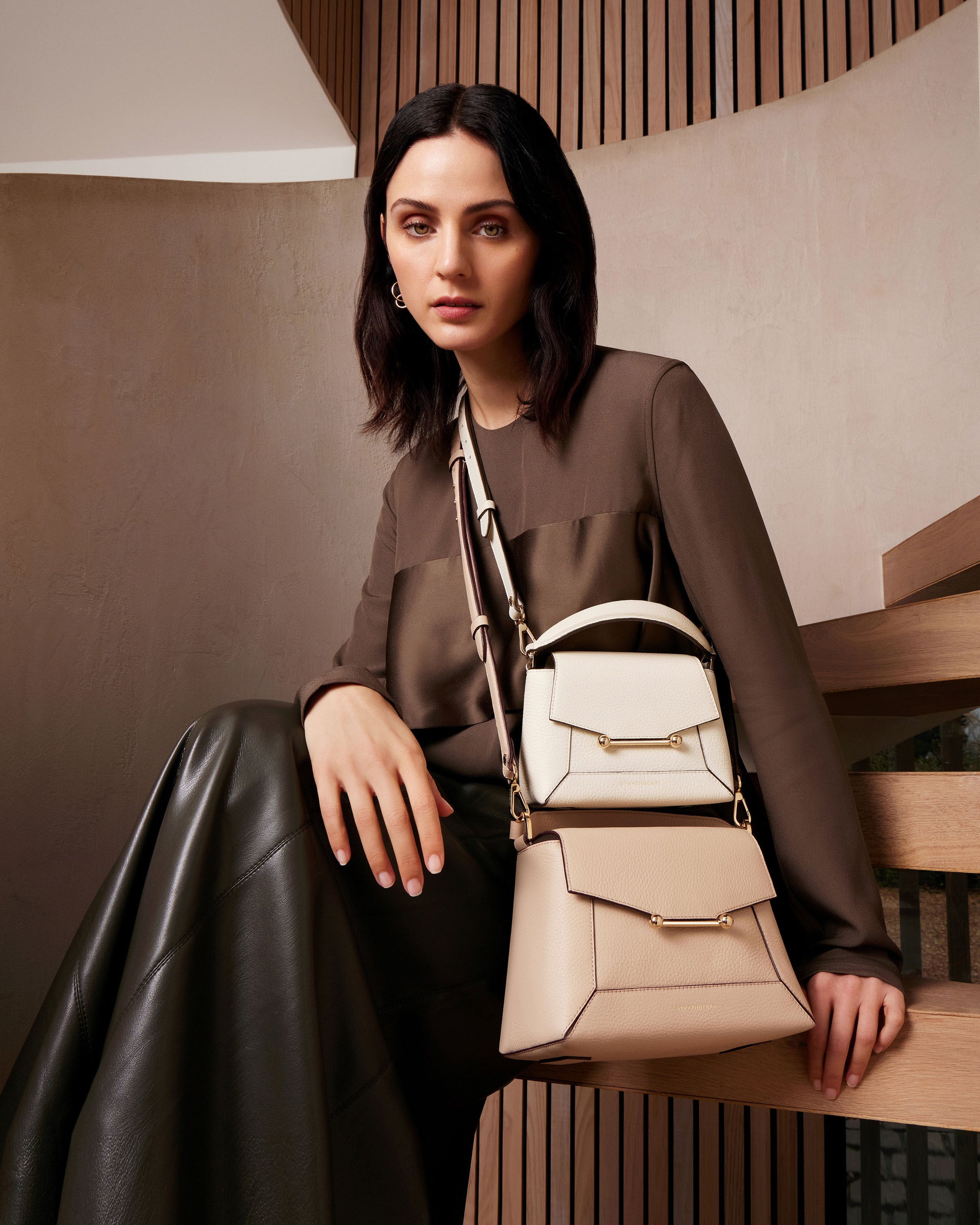 A woman sitting on a bench holding a purse