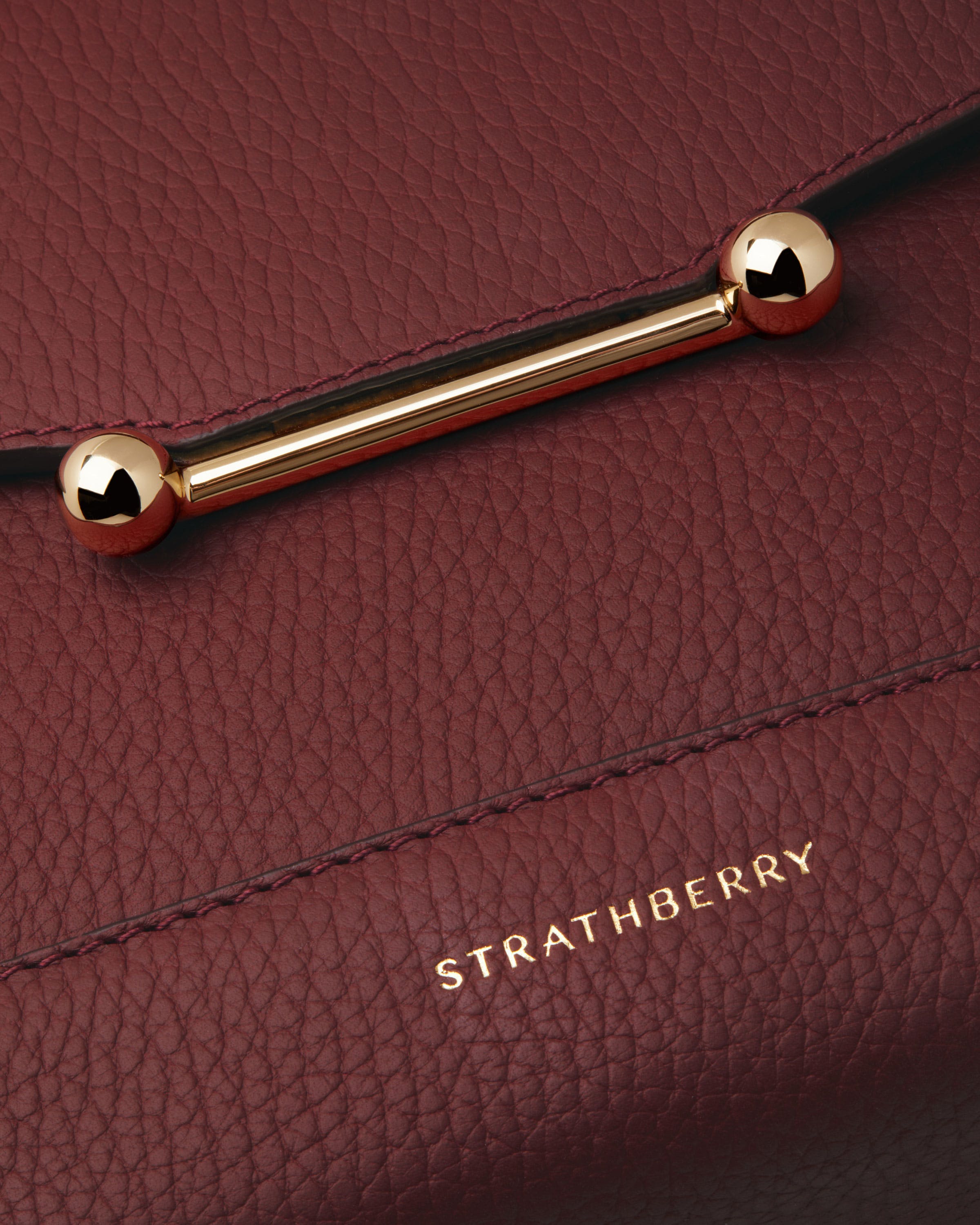 A close up of a red bag with a gold handle