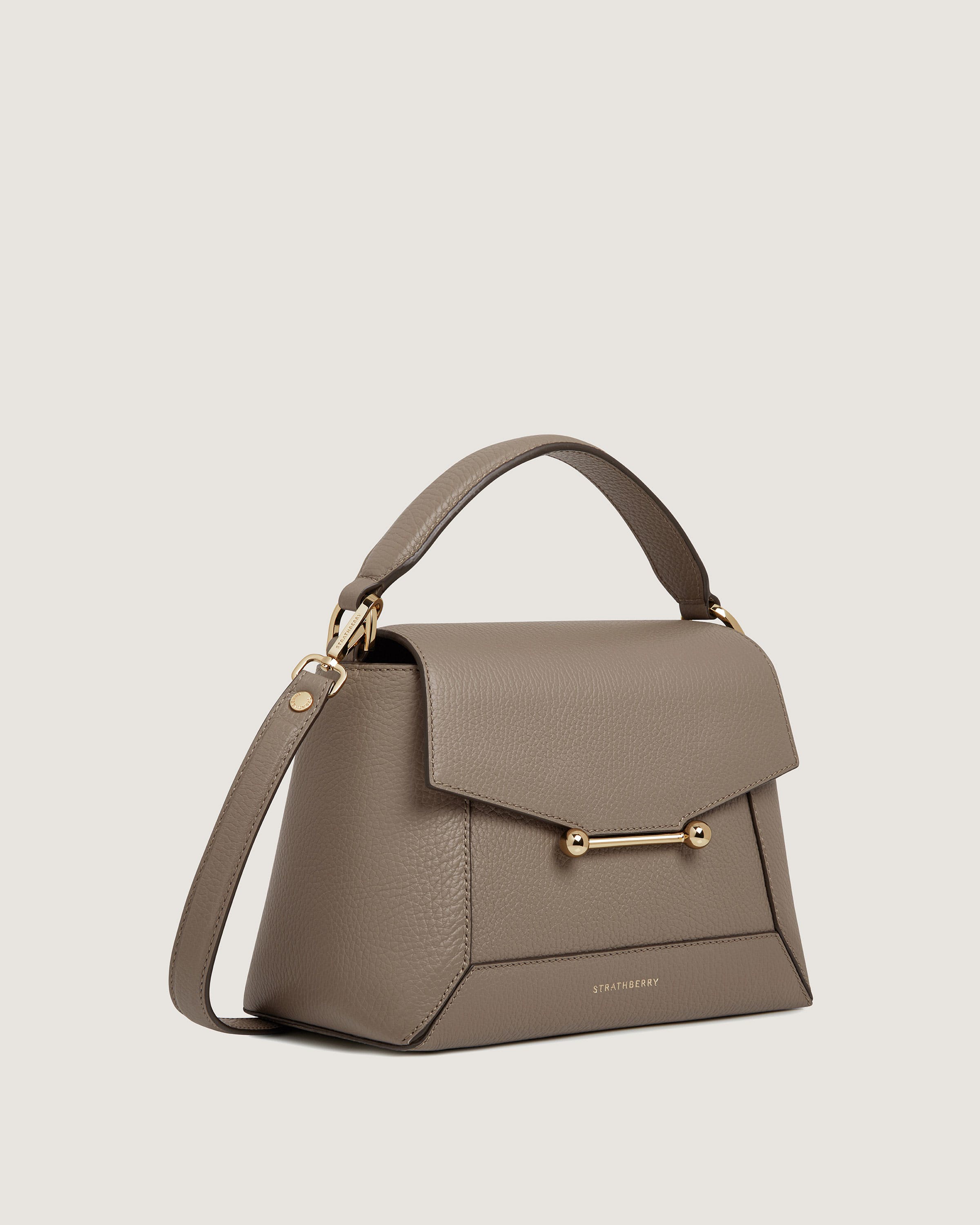 A grey handbag with a gold handle