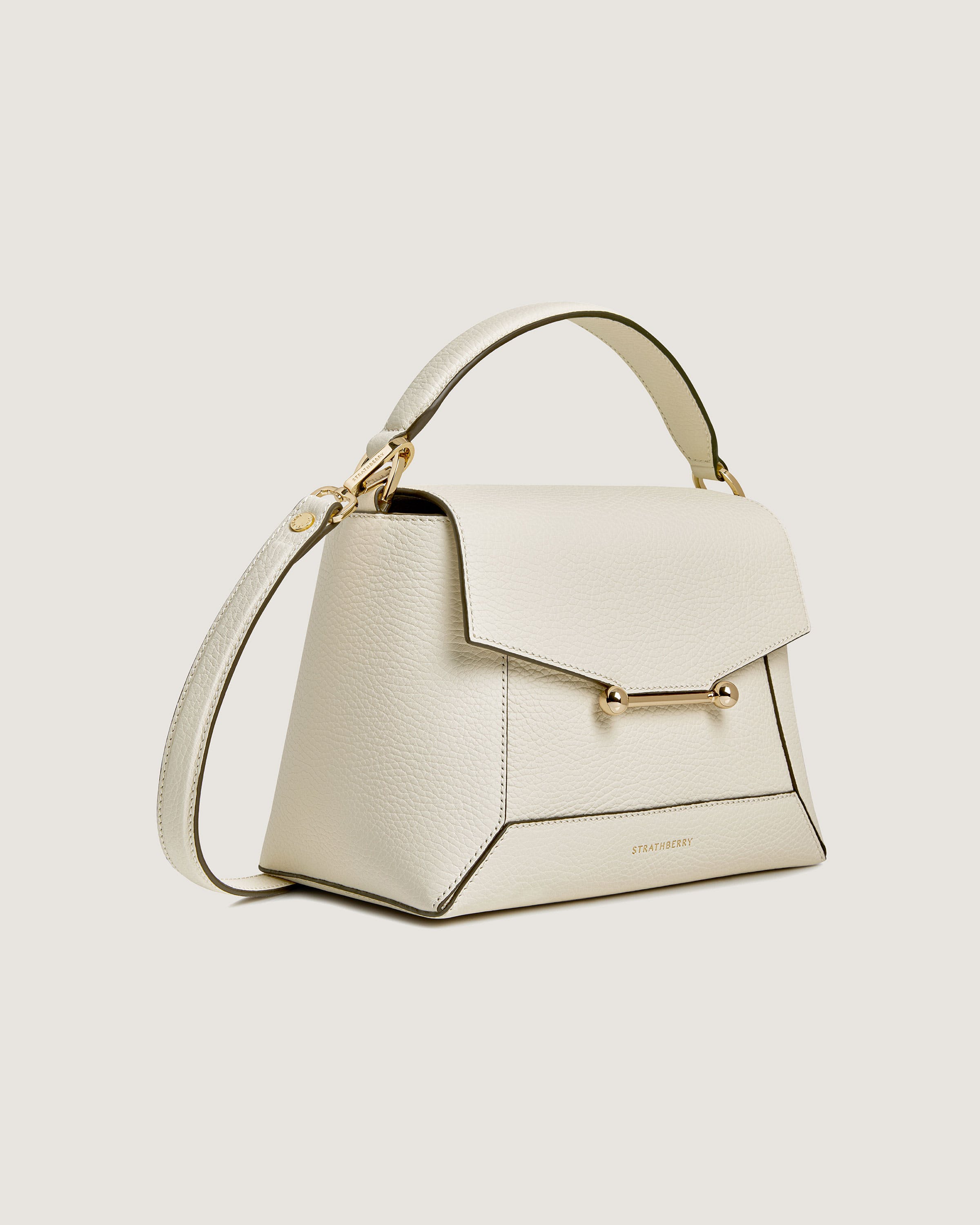 A white handbag with a gold handle