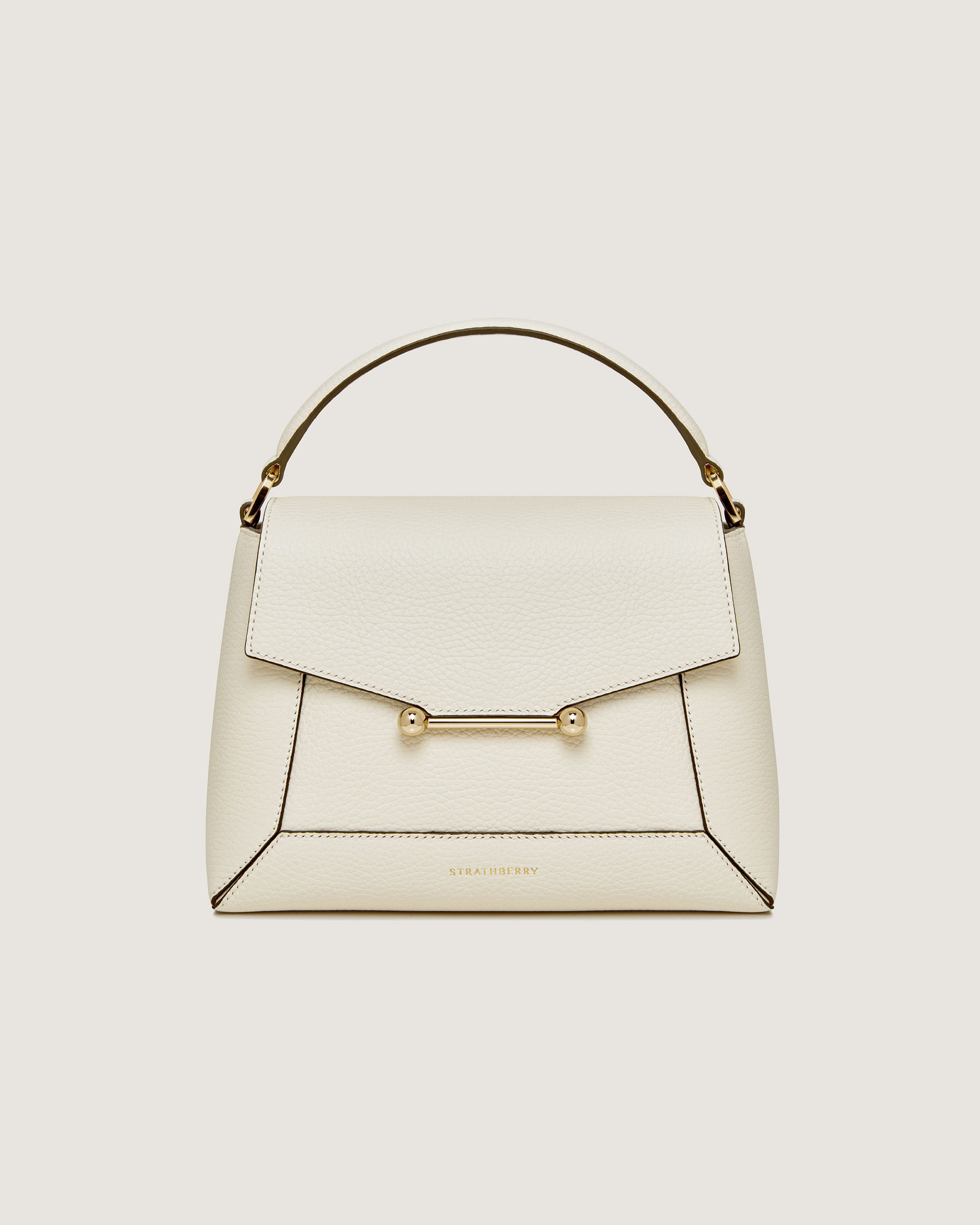 A white handbag with a gold handle