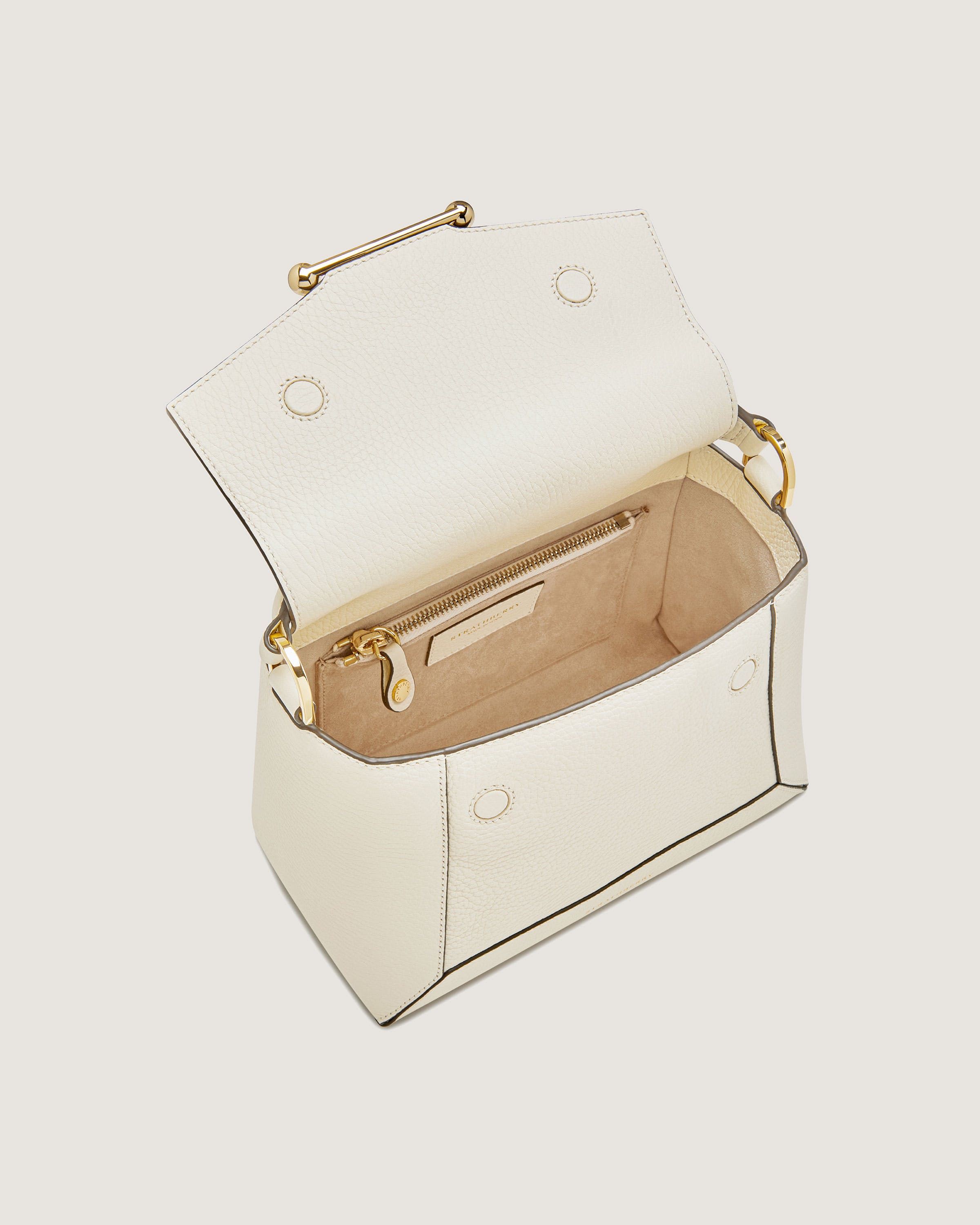 A white handbag with a gold handle