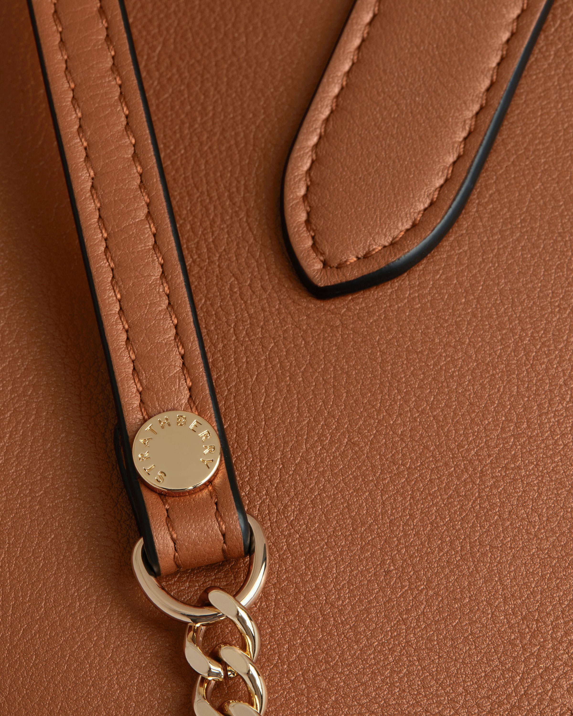 A close up of a brown purse with a key chain