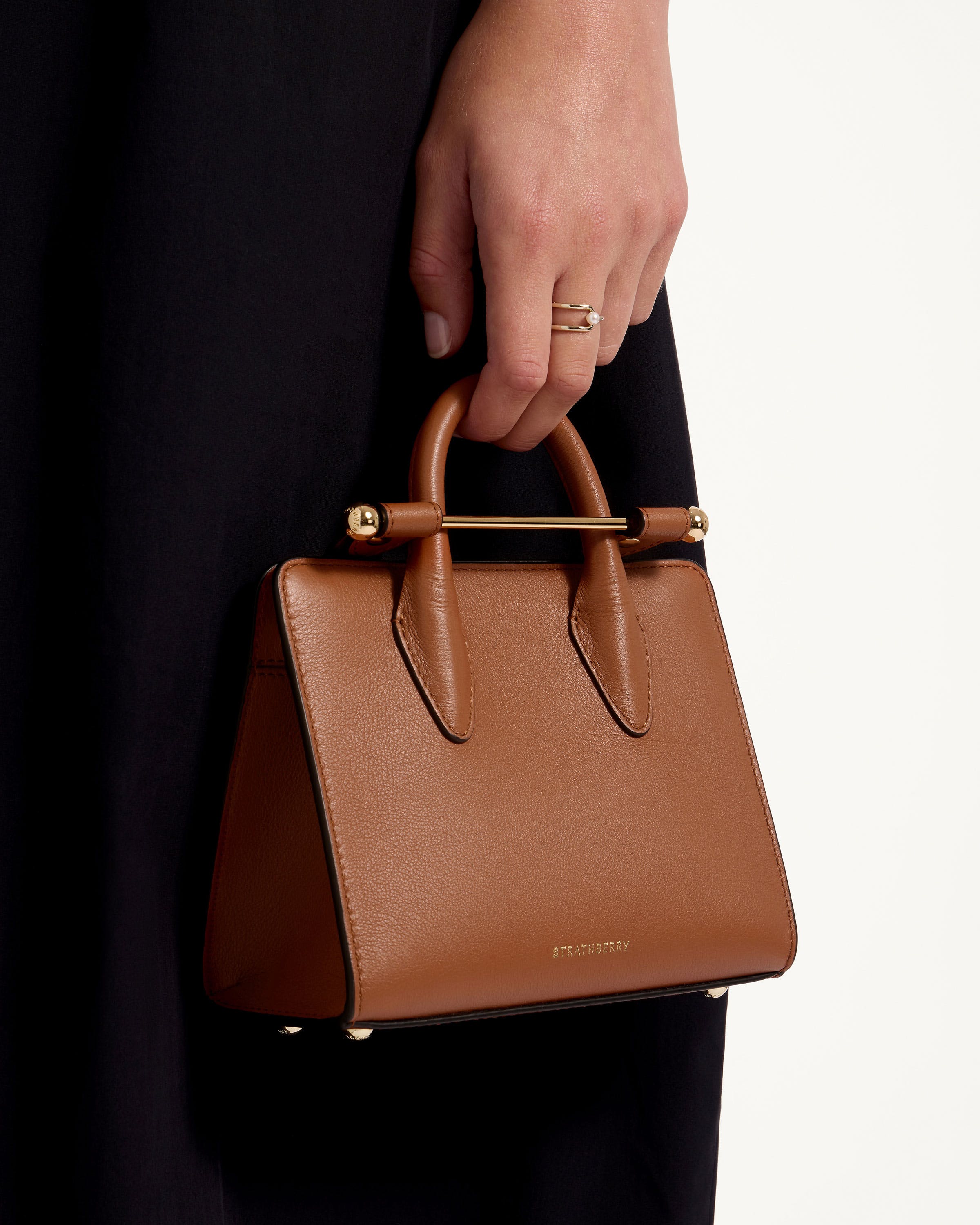 A person holding a brown purse in their hand