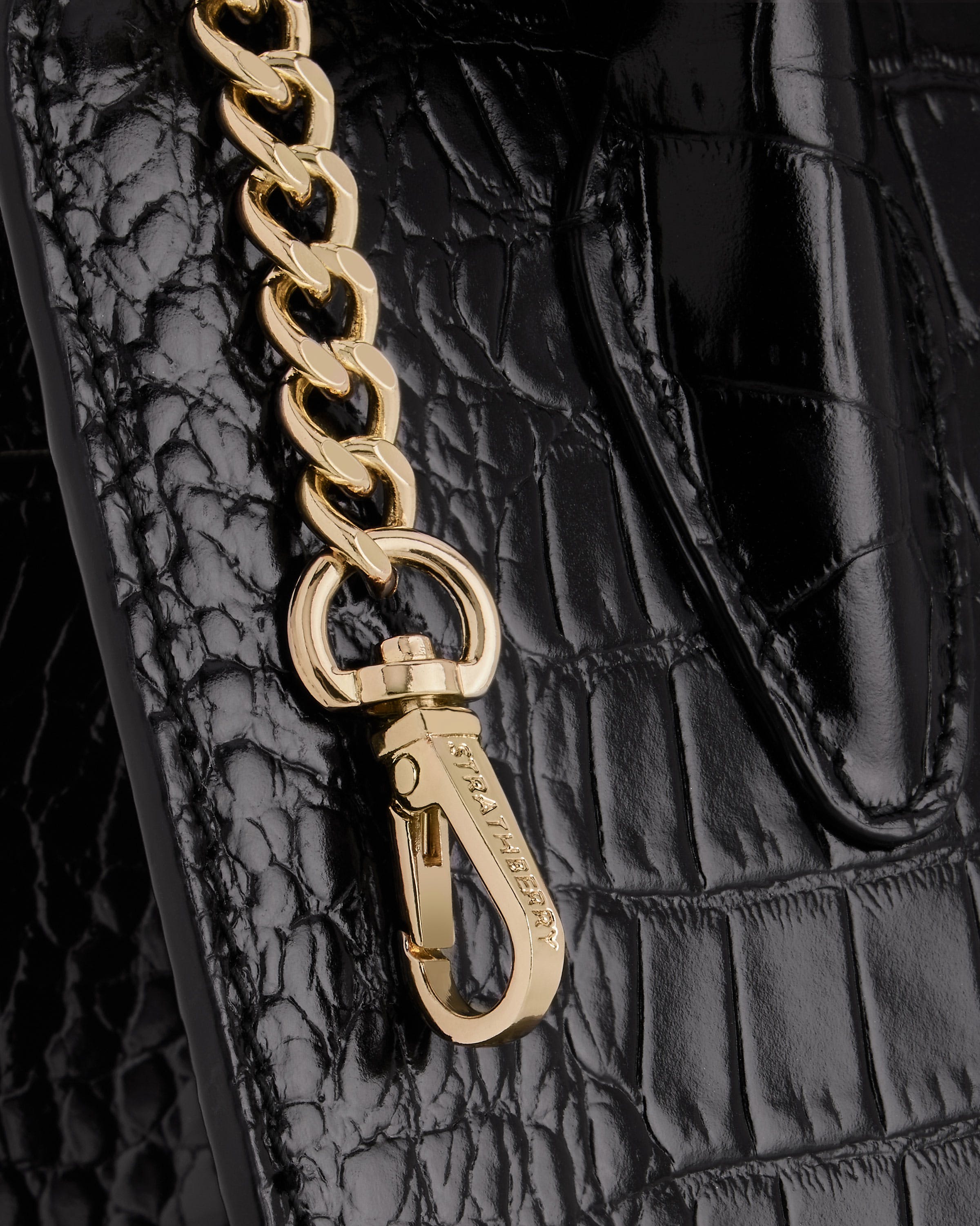 A close up of a chain on a black purse