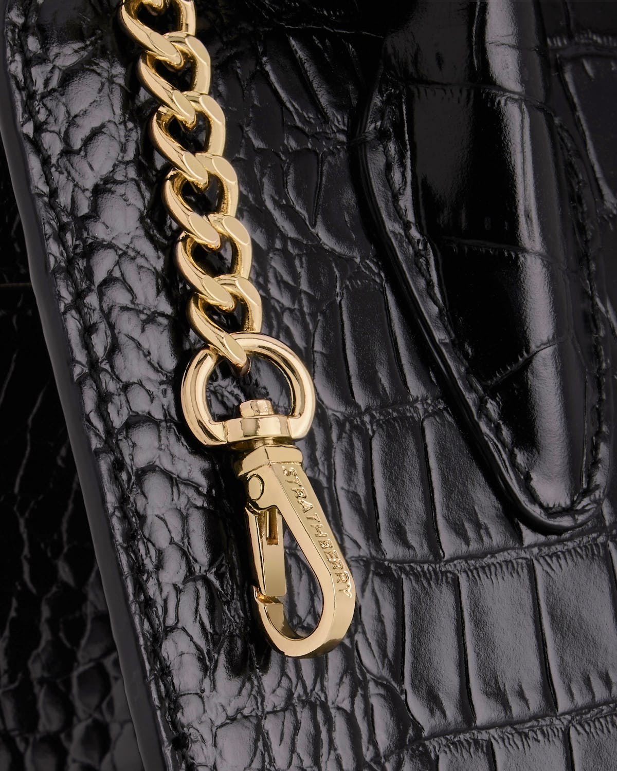A close up of a chain on a black purse
