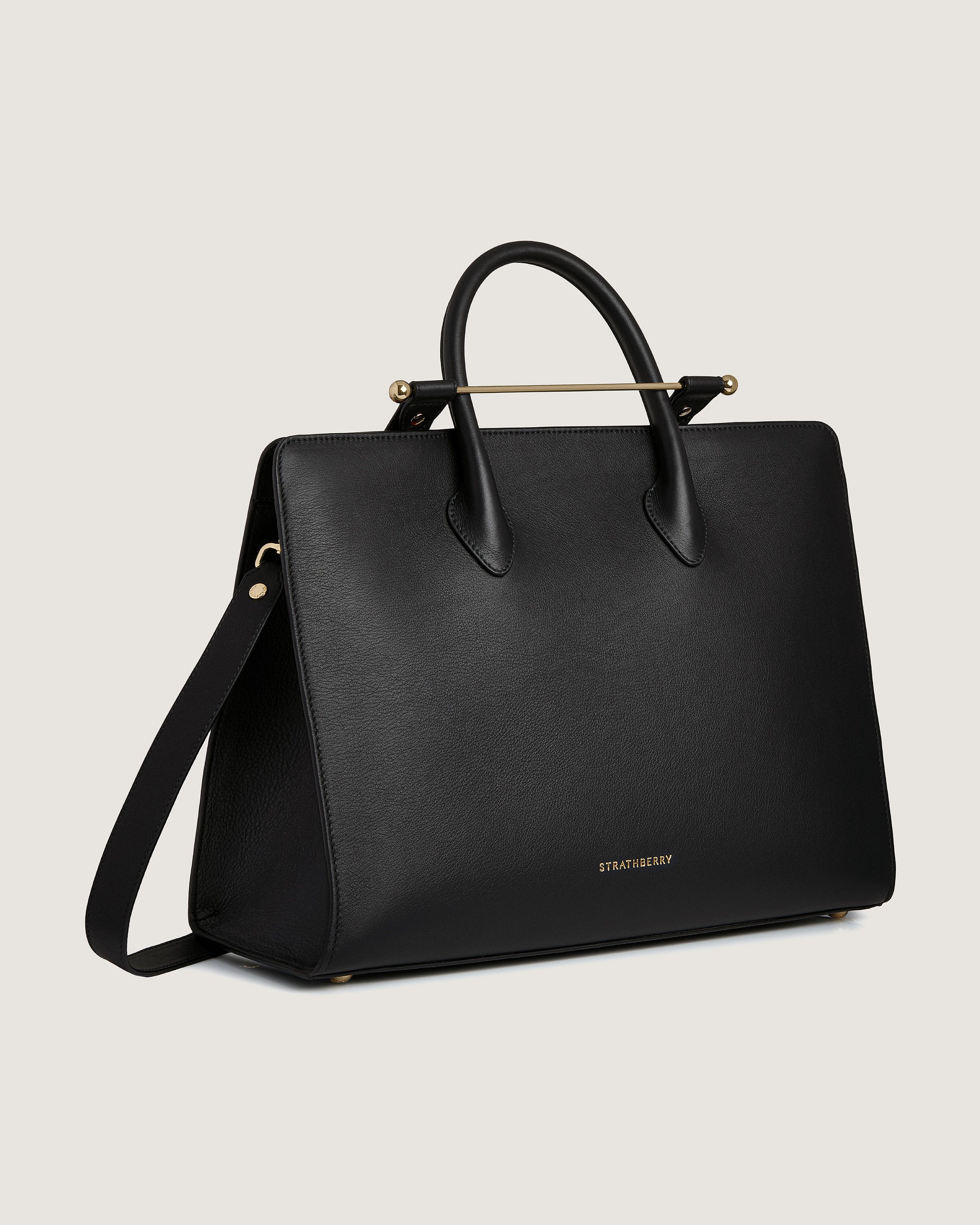 A black handbag with a gold handle