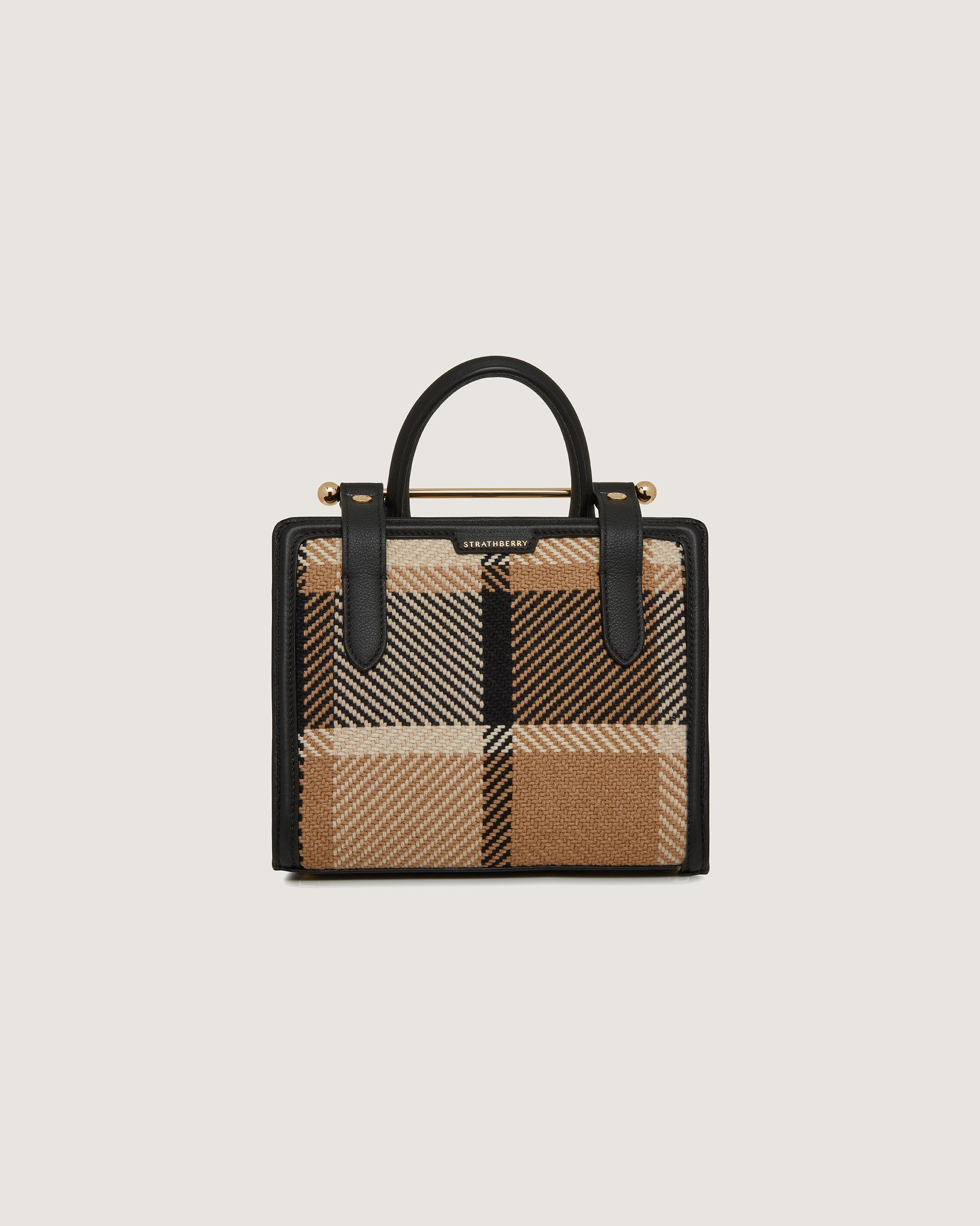 A black and tan checkered handbag on a white background