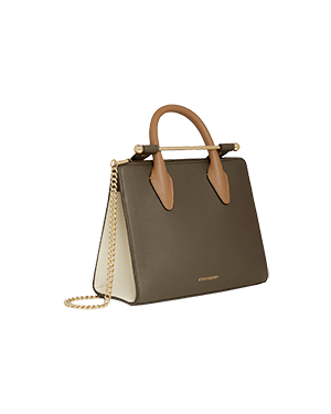 A brown and white handbag on a green background